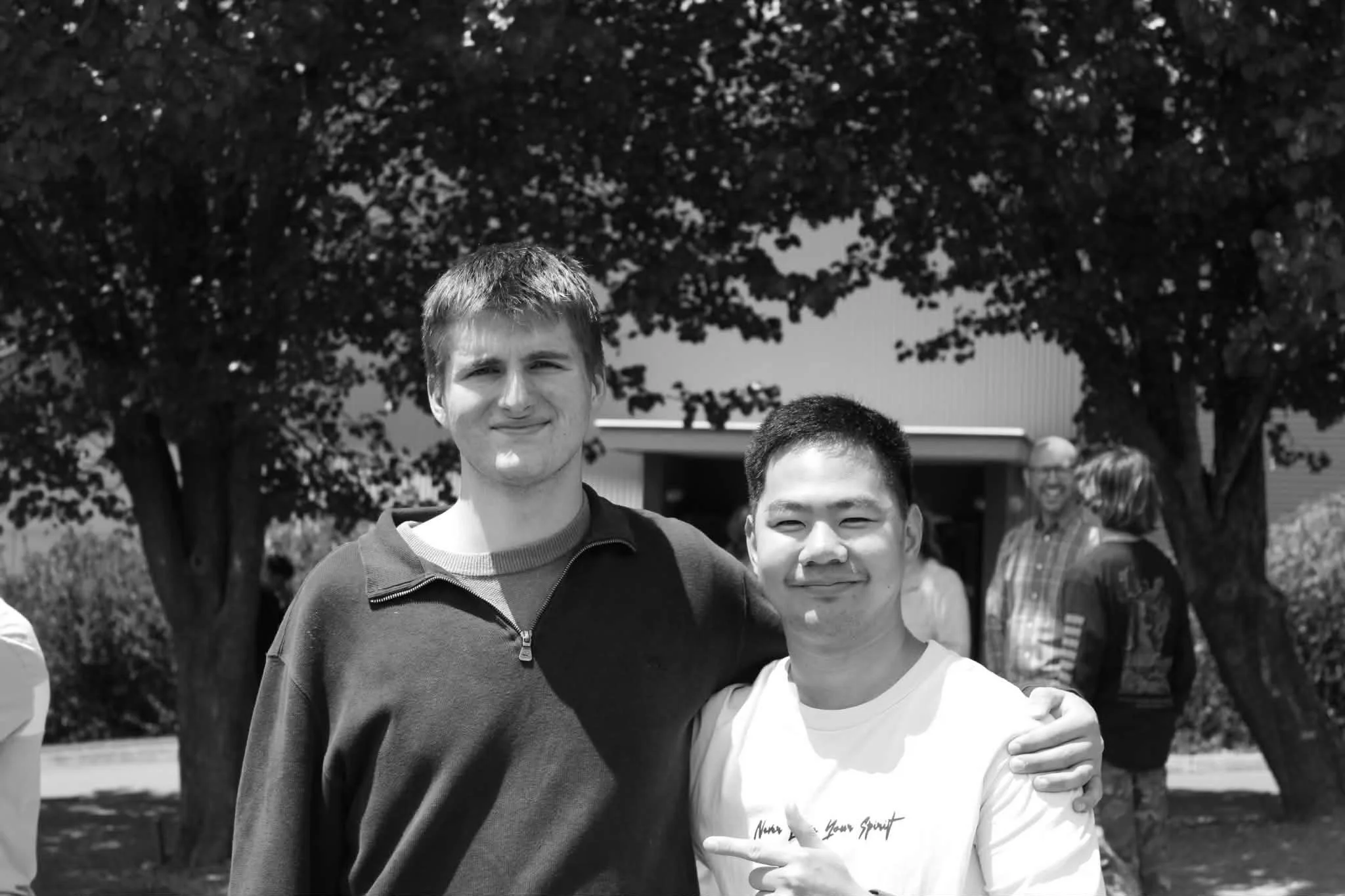 Co-founders of vssls, Joel (R) and Luke (L). Photo taken outside, both smiling, with people and trees in the background.