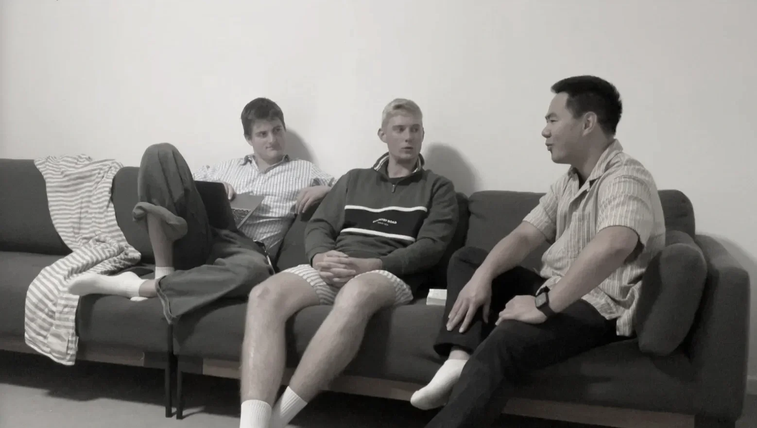 Luke Howis, Jordan Pfeiffer and Joel Chan sitting on a living room couch having a conversation about the song "Friend to me" by vssls.