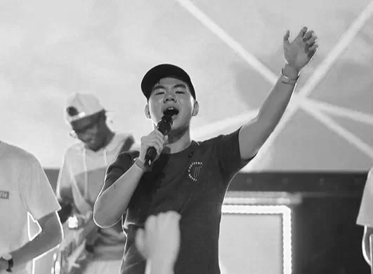 Joel Chan leading worship at a youth gathering — one of many moments of obedience in his years of youth ministry