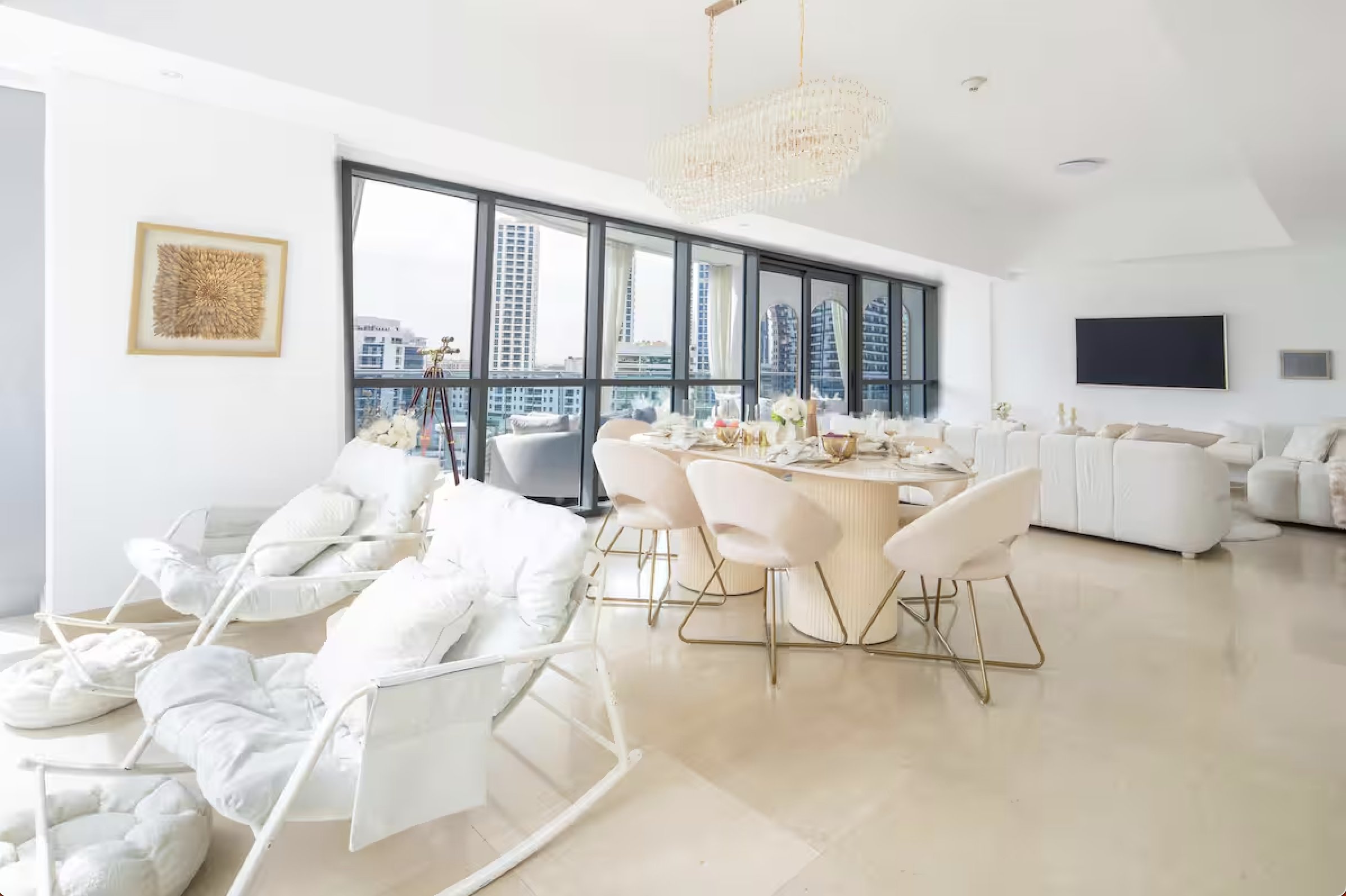 Light-filled living and dining area with a balanced, neutral interior design and city views.
