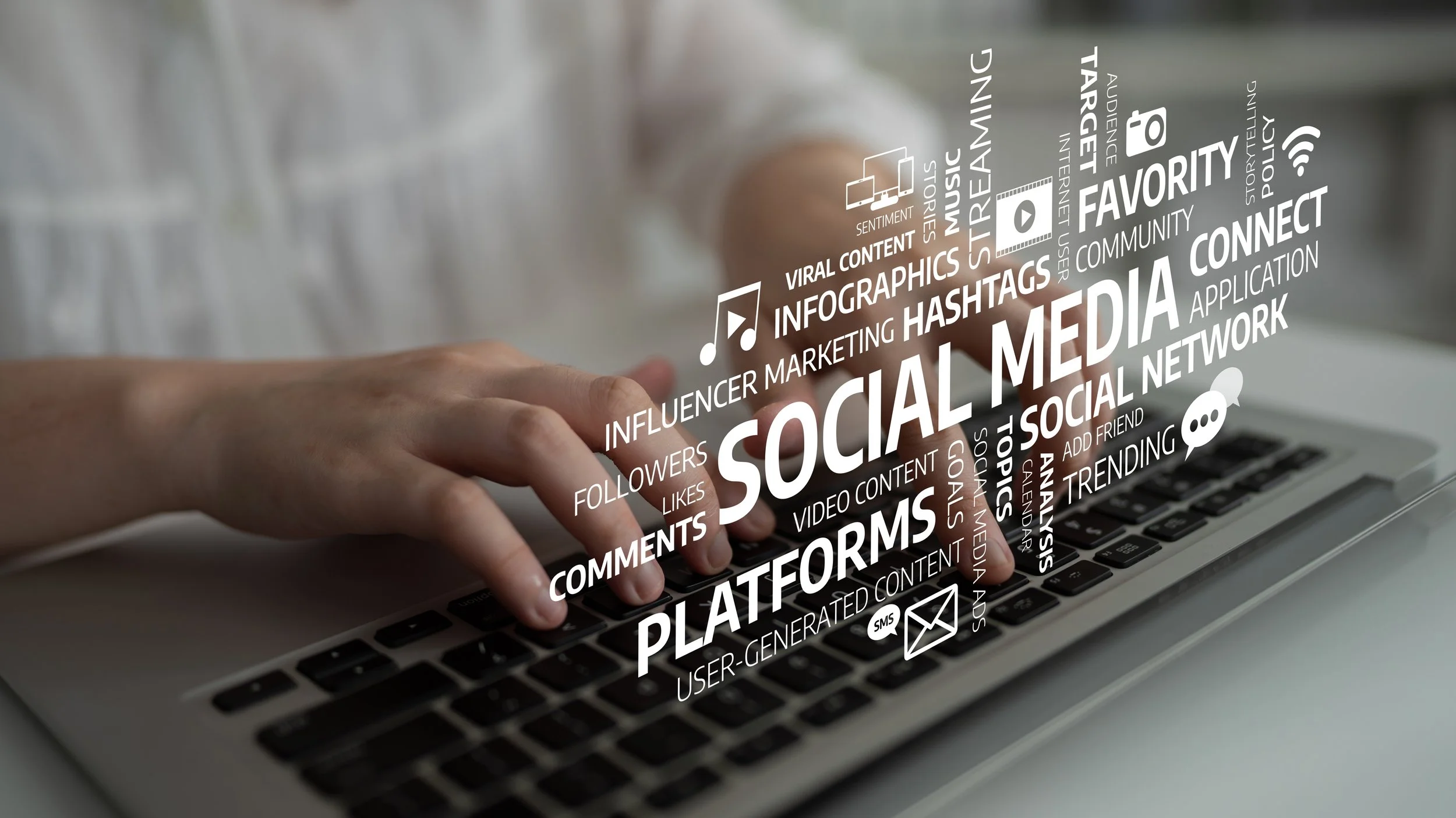 A person's hand typing on a laptop keyboard with a digital overlay of social media related words and icons, including 'social media,' 'platforms,' 'hashtags,' and 'comments.'