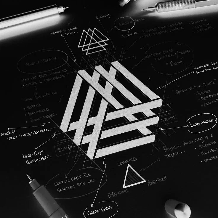 A blackboard with white chalk drawings and notes illustrating a design or concept, featuring geometric shapes and annotations.