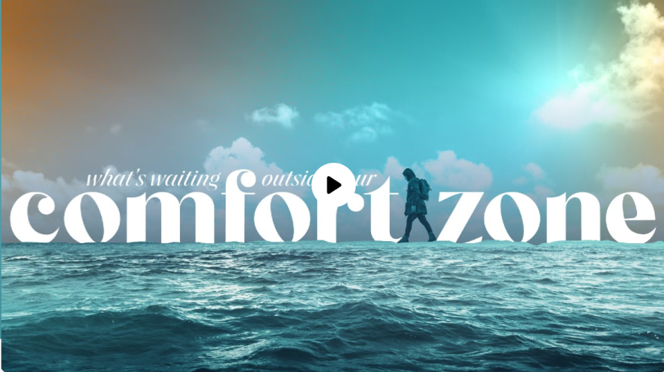 A person with a backpack walking along a horizon line above ocean waves, with a cloudy sky and sunlight in the background, and text that reads 'what's waiting outside your comfort zone'.