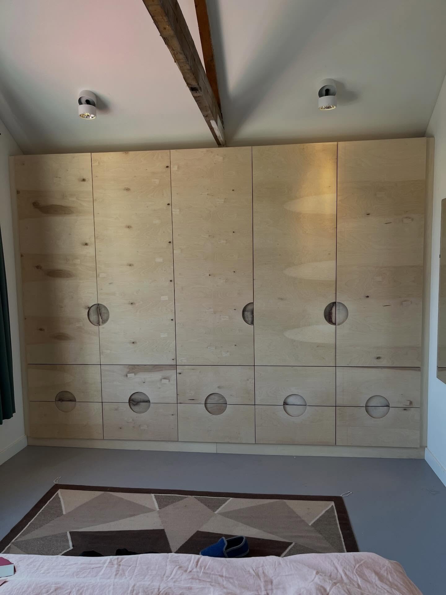 Garderobe kast met uitgefreesde handvaten onder een schuin dak. De lades aan de onderkant zijn lekker diep waardoor je er veel in kwijt kan. Ik heb de kast ook om de bestaande houten balken van het huis gebouwd.