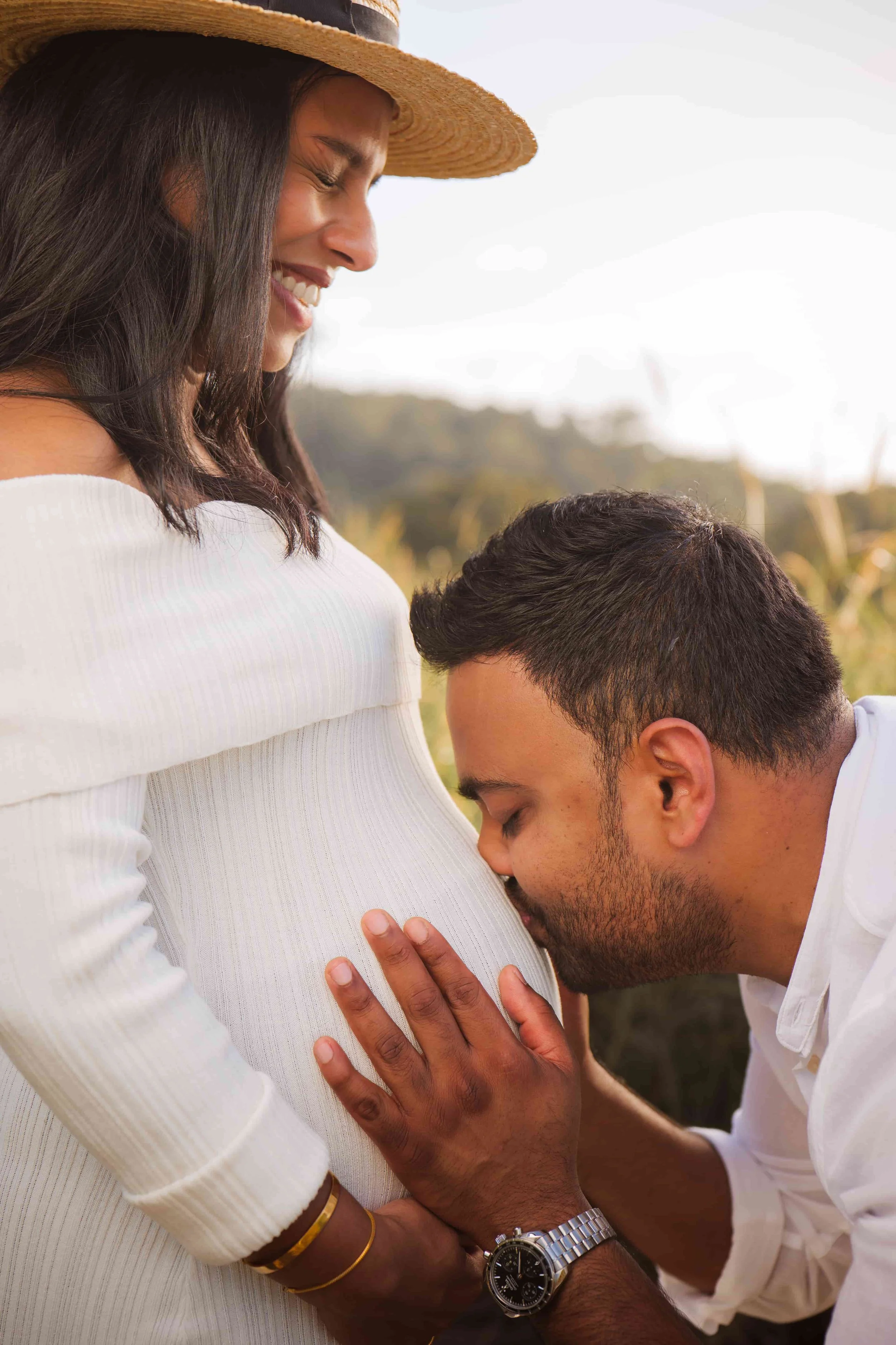 husband kissing pregnant belly