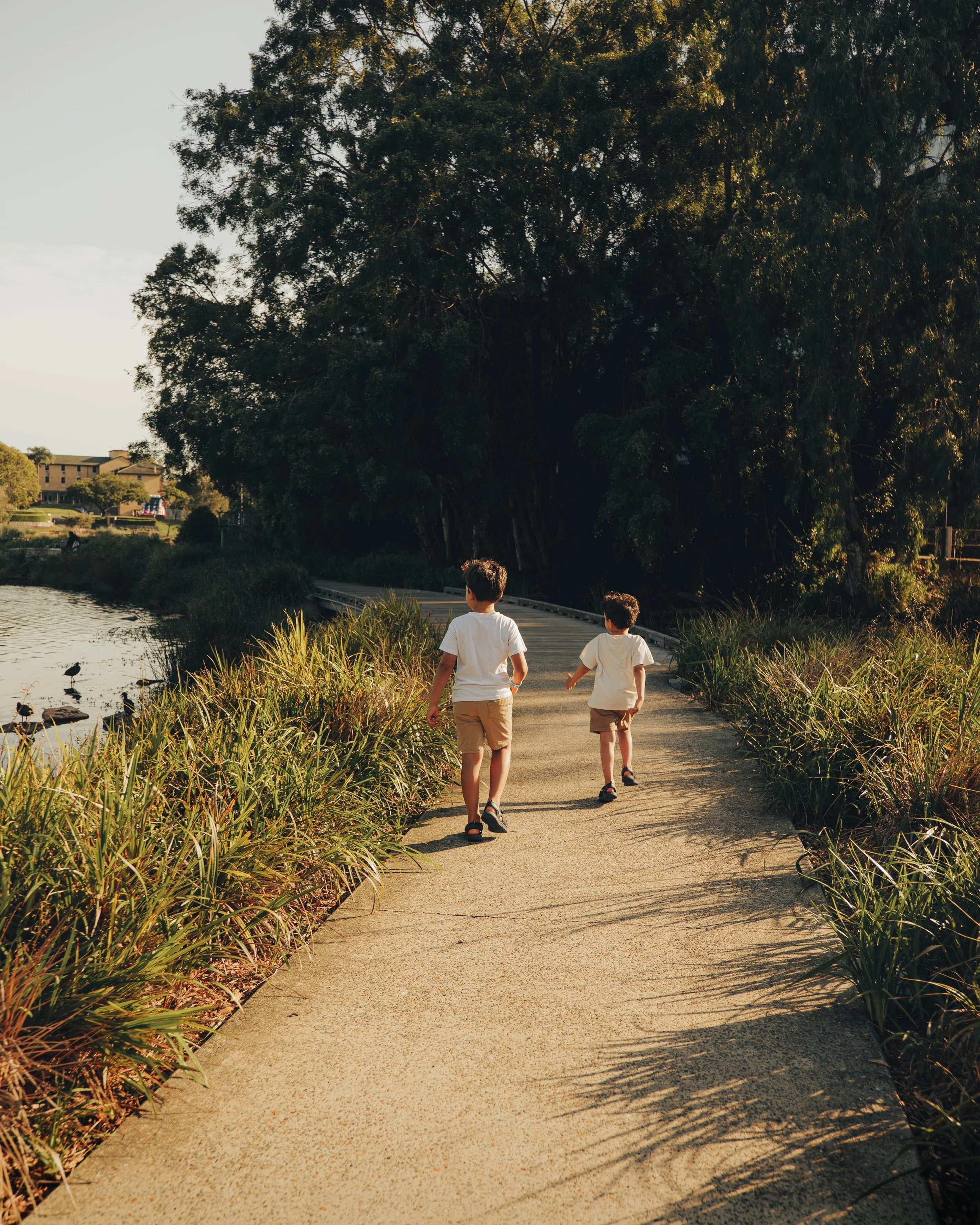 borthers running along a lake