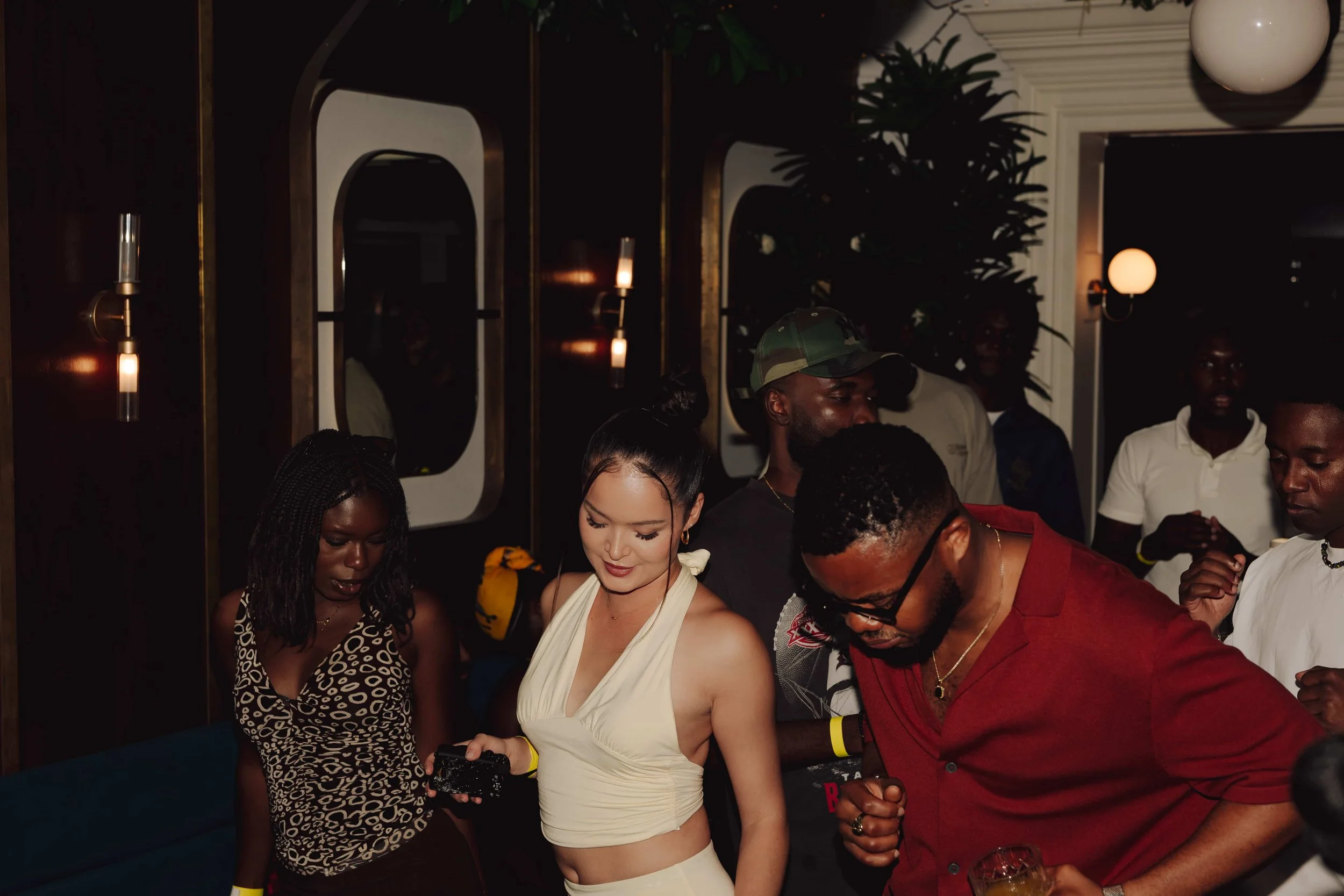 Group of people at a party in a modern room dancing and having fun.