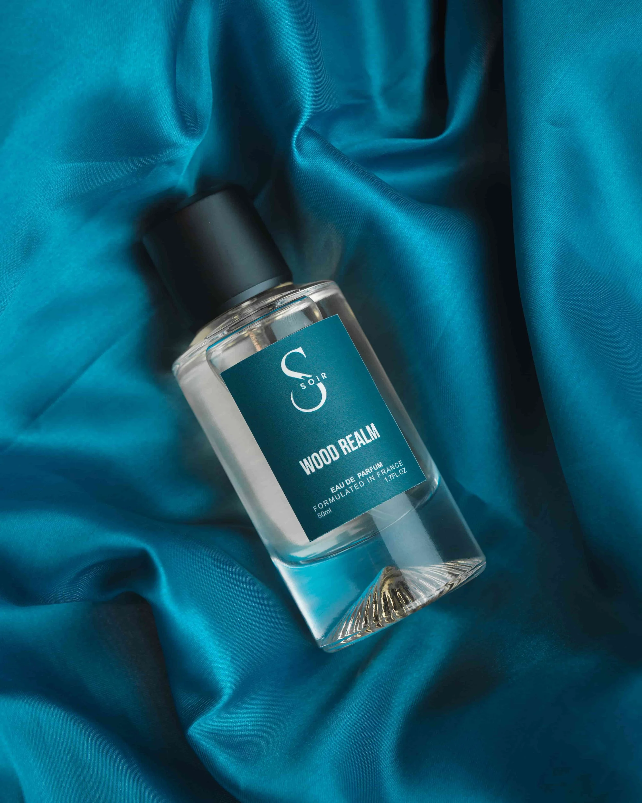 fragrance bottle with teal backdrop