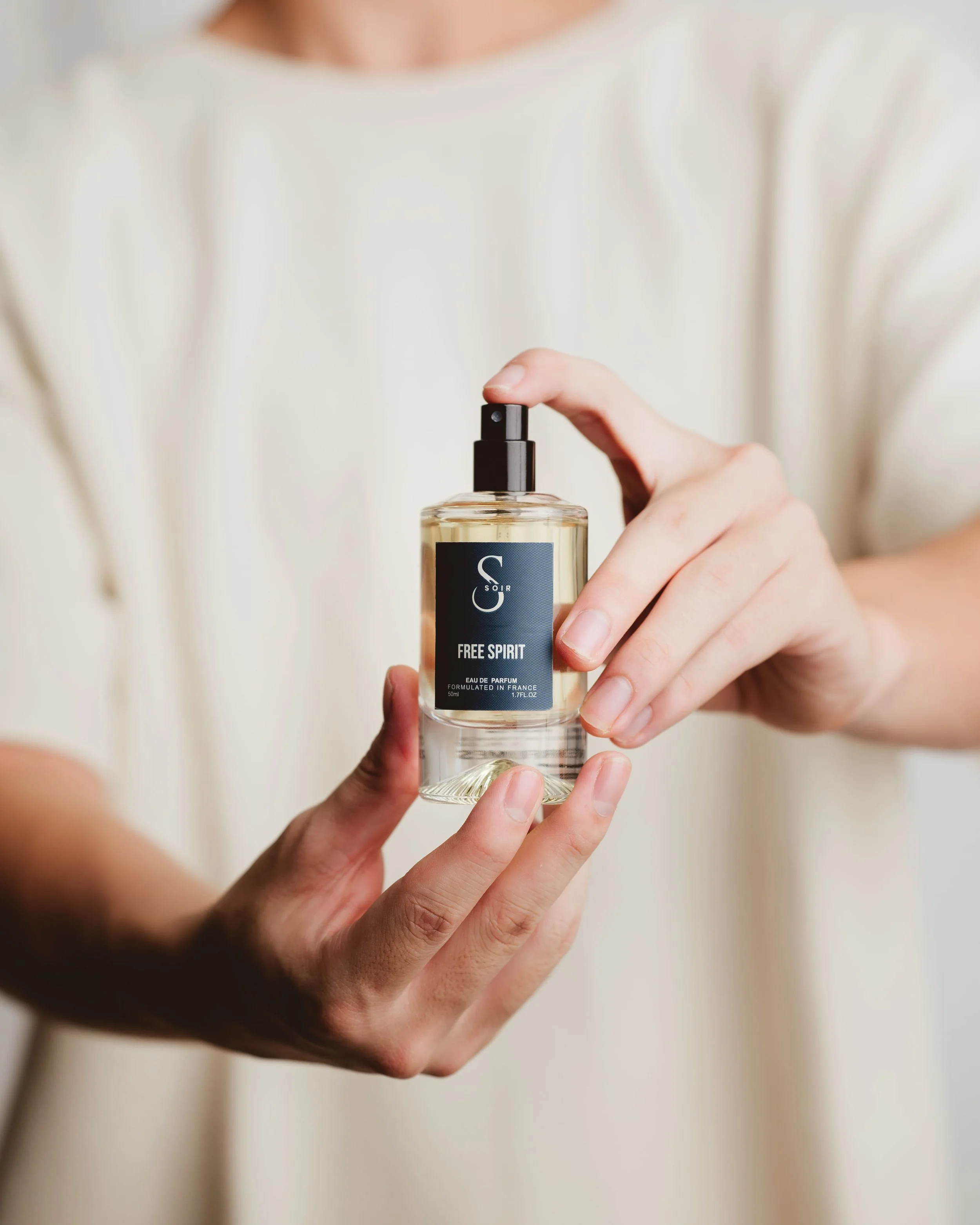 Man holding perfum bottle with extended arms