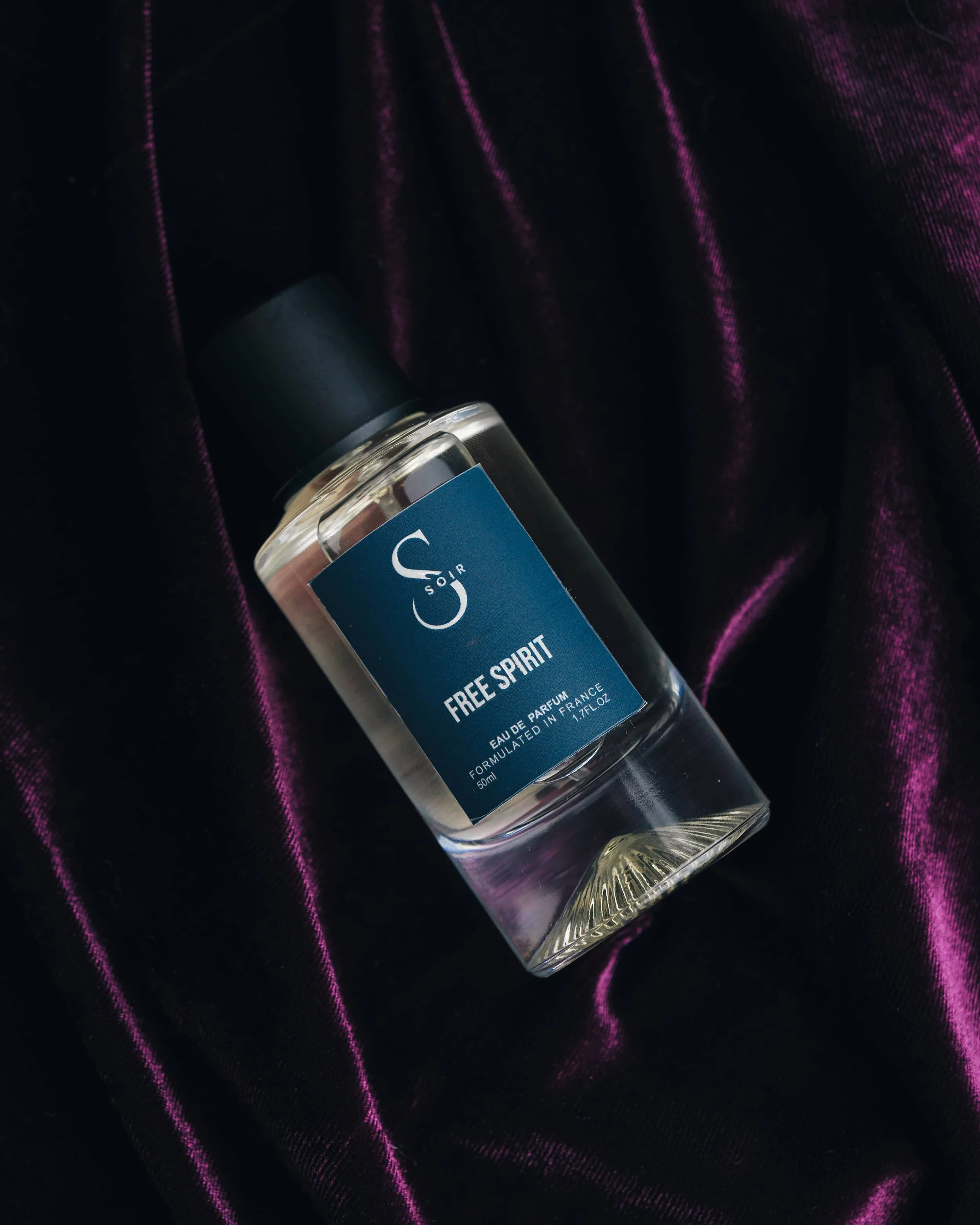 bottle of fragrance with purple backdrop