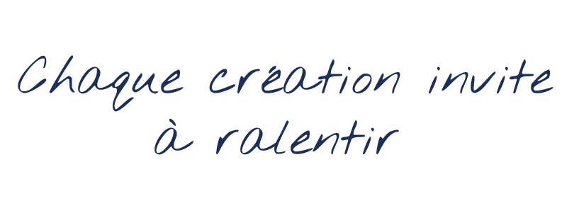 Texte en français disant : "Chaque création invite à ralentir" en écriture cursive bleue sur fond noir.