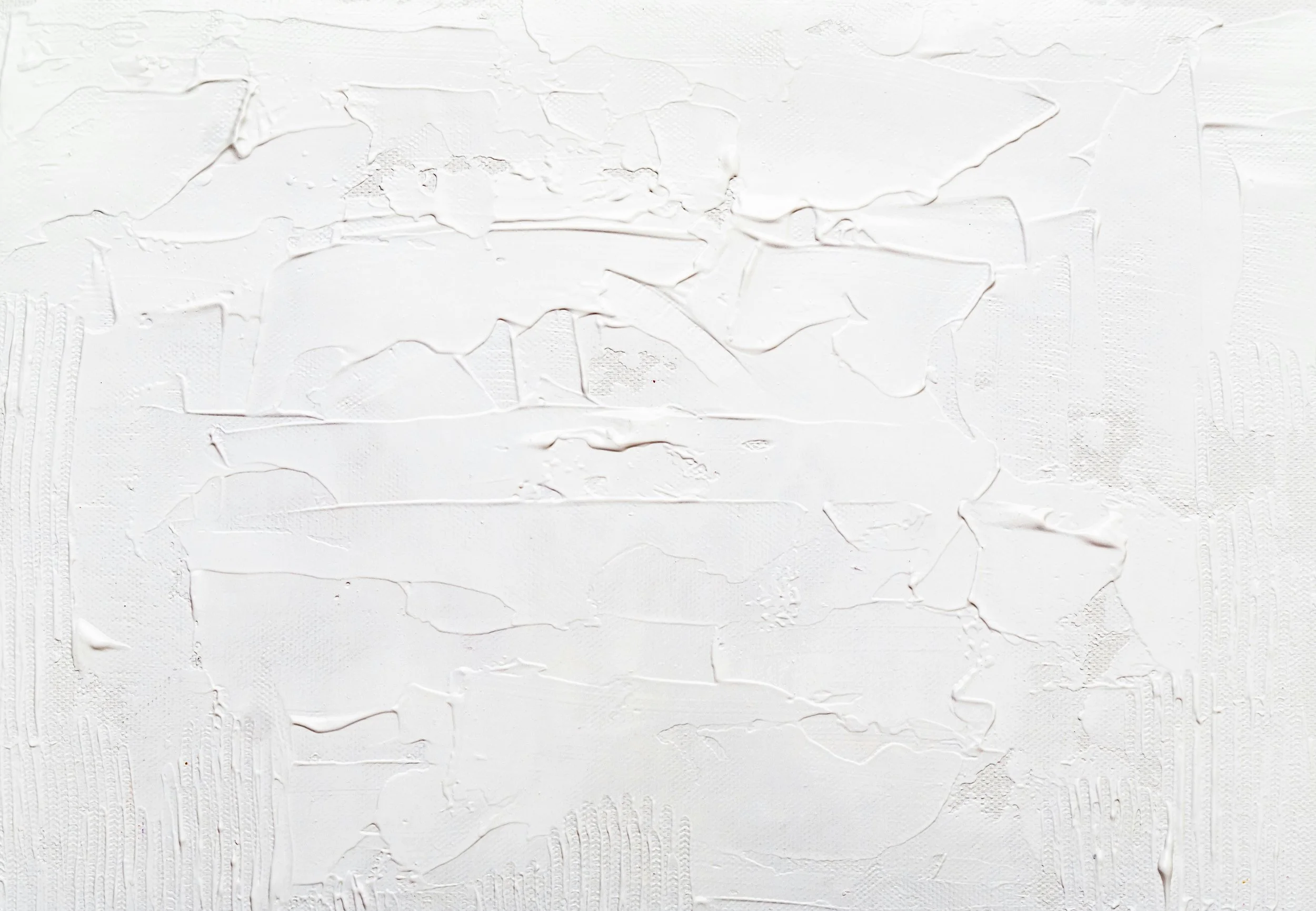 Close-up of a white textured surface with uneven, cracked, and layered paint or plaster.