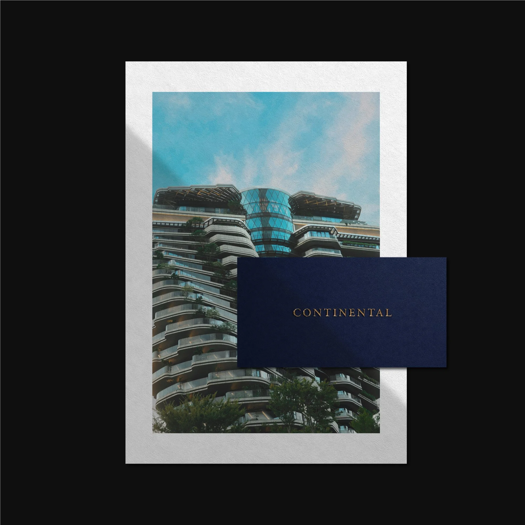 Navy business card overlaid on framed architectural photography mockup for luxury real estate brand.