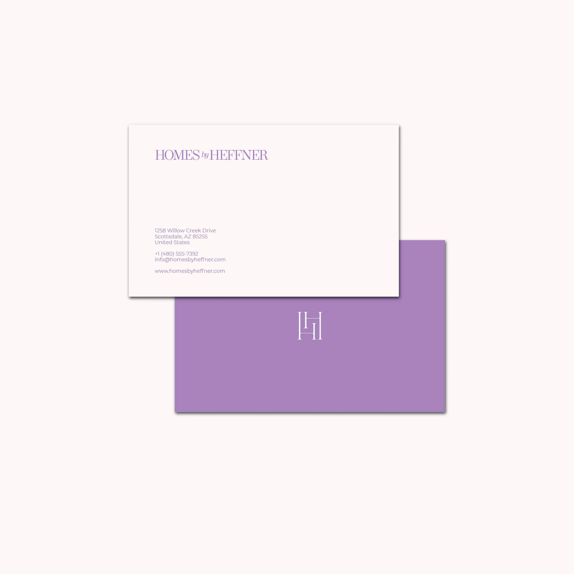 Business card design featuring purple and white color scheme, with the logo 'H' and 'H' intertwined, and contact information for Homes by Heffner.