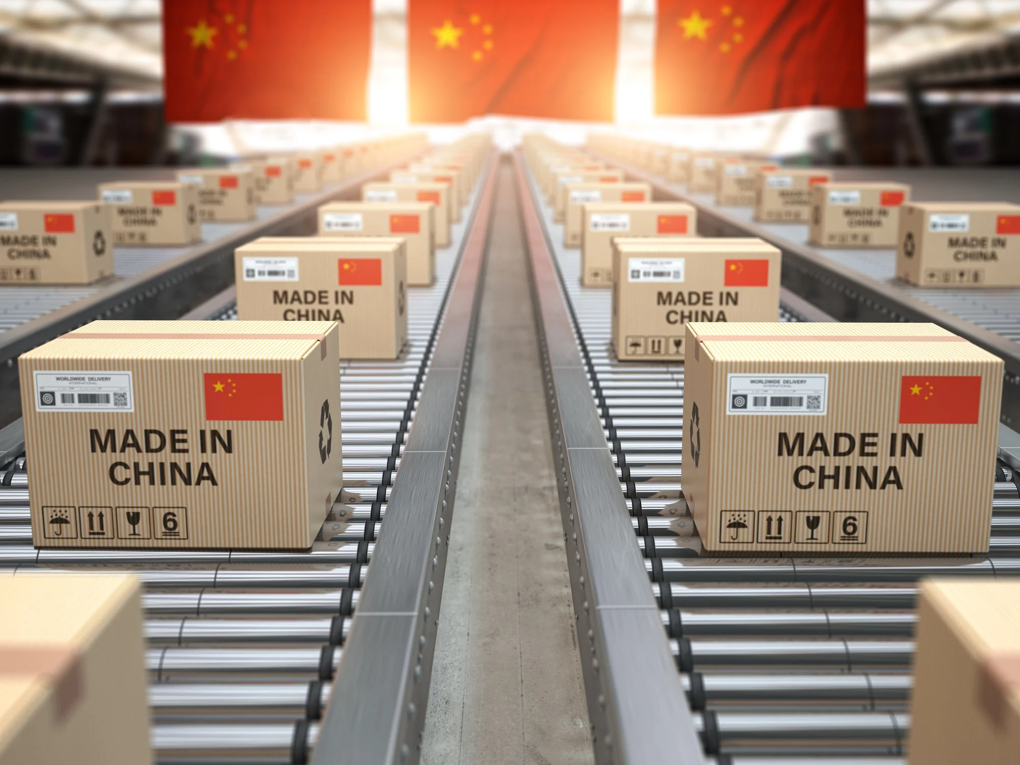 Multiple cardboard boxes on a conveyor belt in a warehouse, with a large Chinese flag in the background.