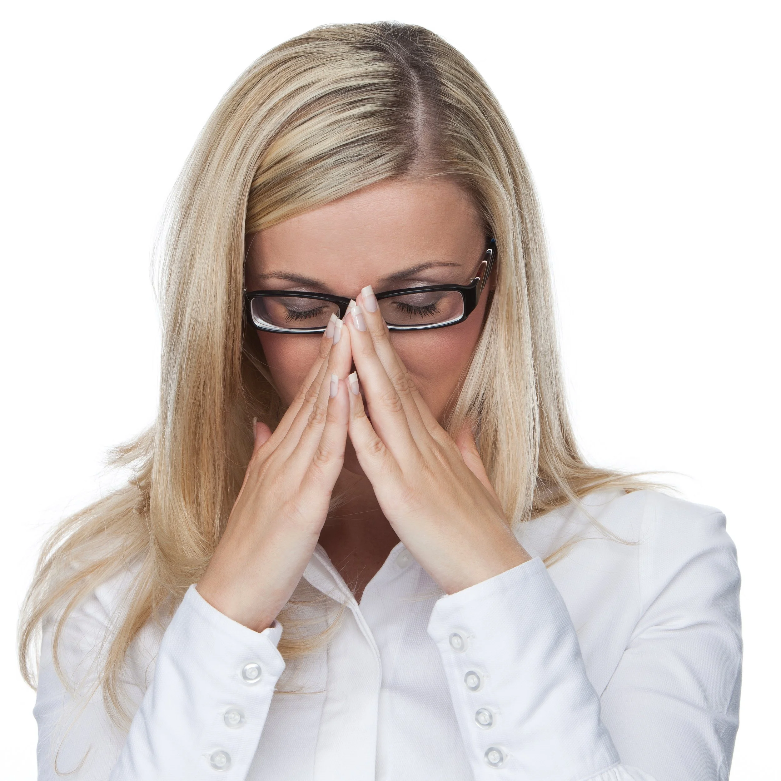 A blonde woman wearing glasses and a white shirt, with her eyes closed and hands pressed together in front of her face in a prayer-like gesture.