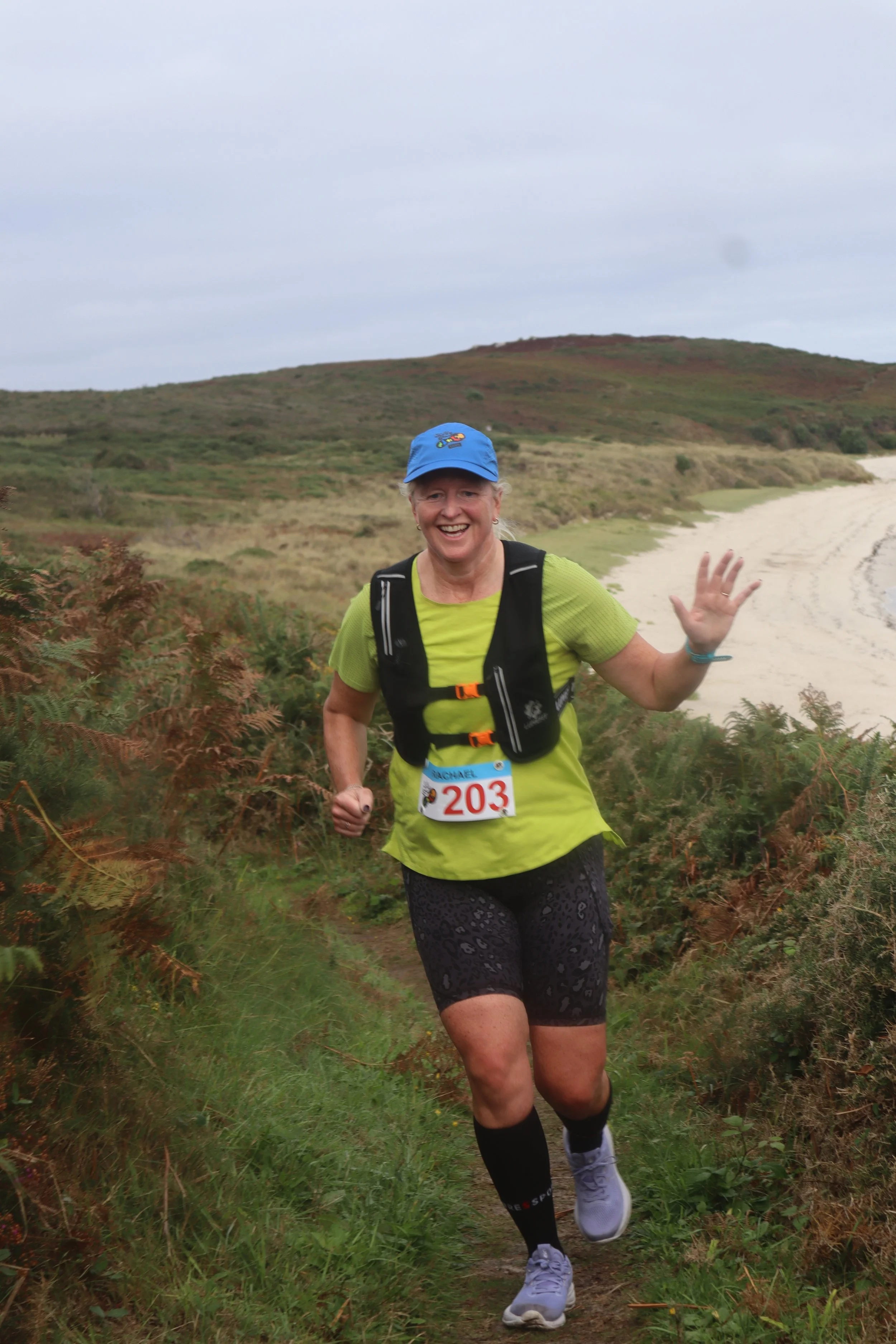 A runer waving on St Martins coast path