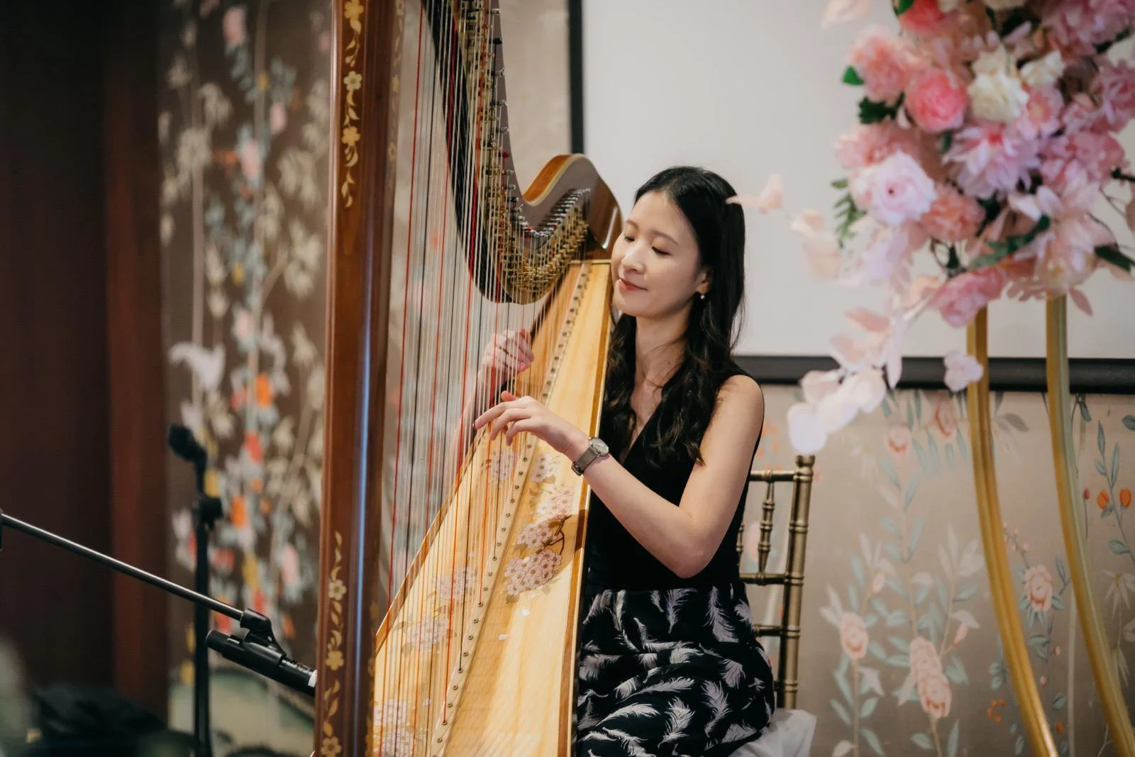 A harpist, Katherine Tay, performs a harp performance at a wedding at the Capitol Singapore