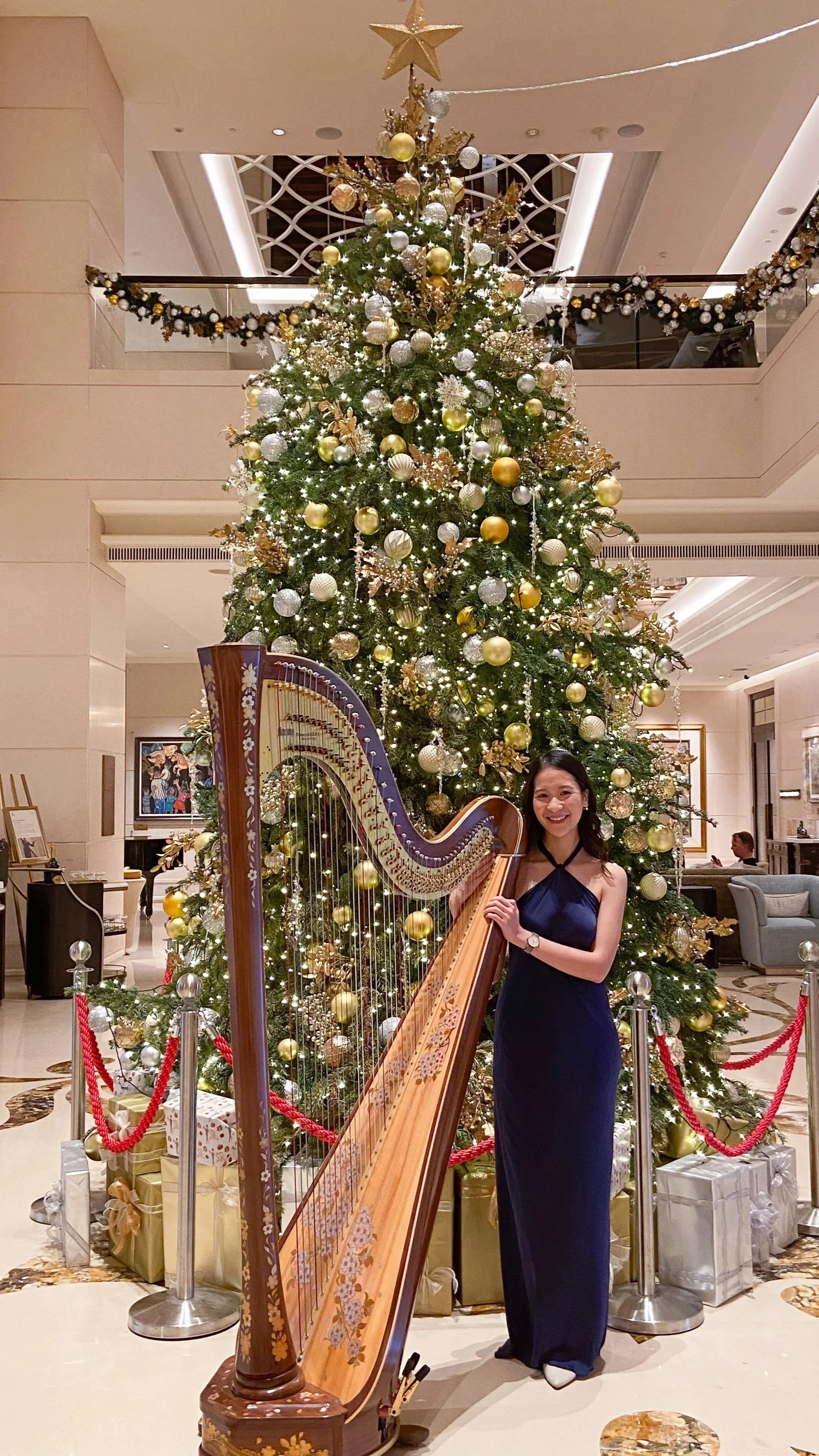 Harpist Katherine Tay standing with her harp at  St Regis Singapore