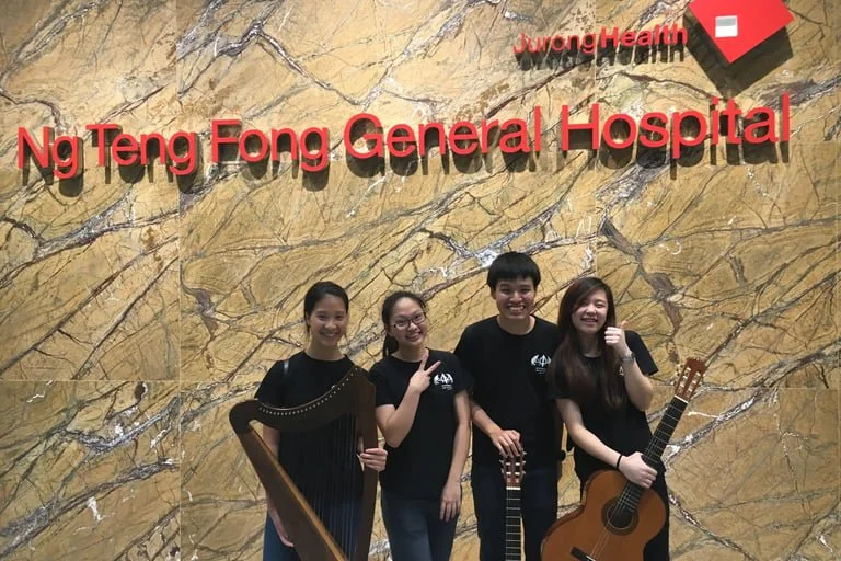 Singapore harpist Katherine Tay, pictured with her friends playing the guitar.
