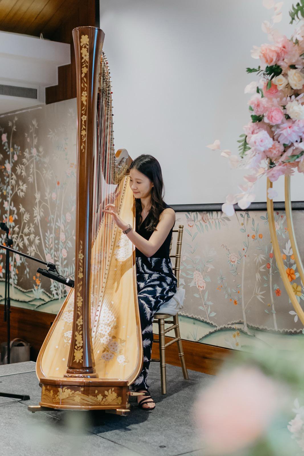Harpist Katherine Tay performing with her harp at The Capitol Kempinski Hotel.