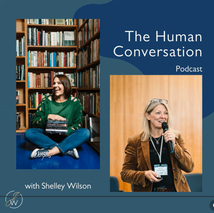 Cover of a podcast titled 'The Human Conversation' with Shelley Wilson. The cover features a split design with a woman sitting in a bookstore on the left and another woman speaking into a microphone at an event on the right.