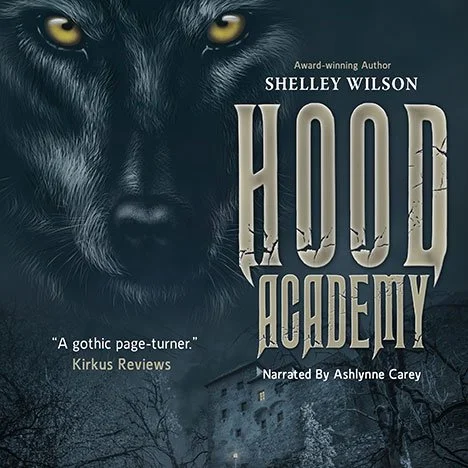 Book cover for 'Hood Academy' by Shelley Wilson, with a black panther's face at the top, dark trees, and a building in the background.