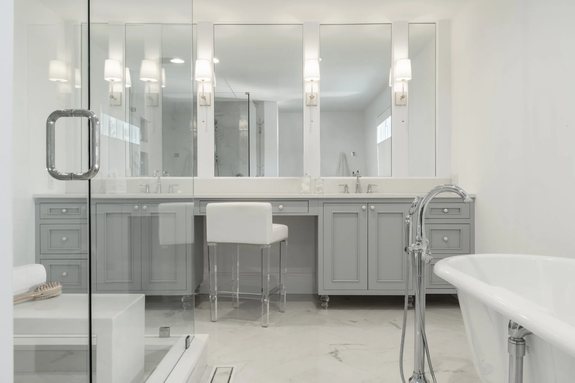 Transitional coastal primary bath with blue-gray cabinets, freestanding tub and walk in shower. 