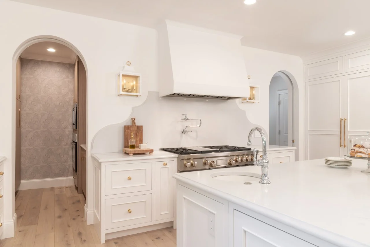 Transitional white inset kitchen with blue bar, professional appliances and brass fixtures. 