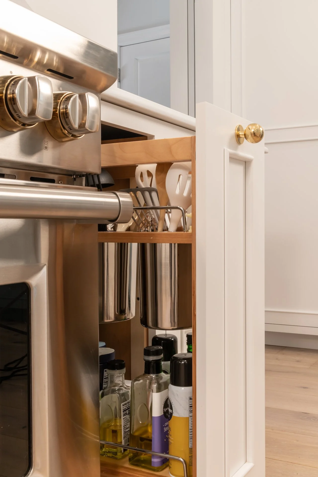 Transitional white inset kitchen with blue bar, professional appliances and brass fixtures. 