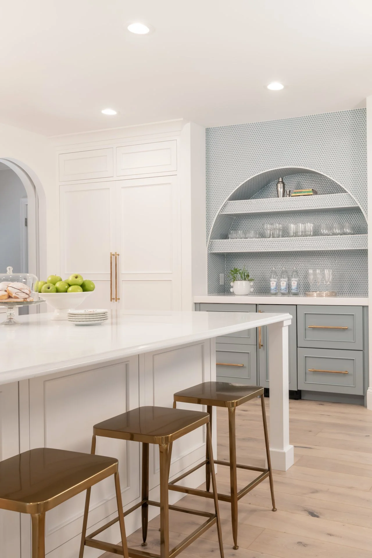 Transitional white inset kitchen with blue bar, professional appliances and brass fixtures. 