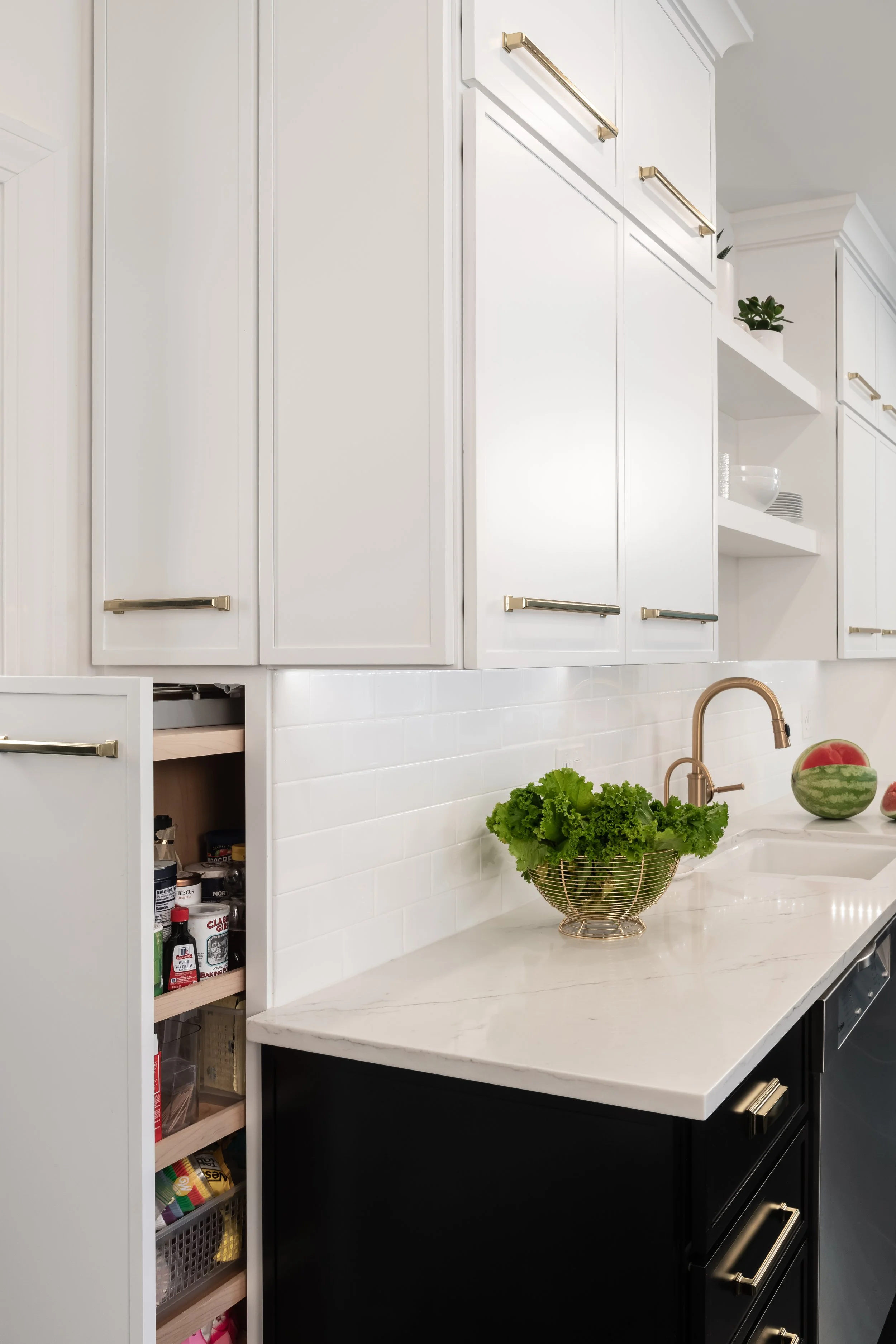 Modern kitchen in a traditional home. Black and white cabinetry and gold fixtures make this kitchen classic while updated and modern. 
