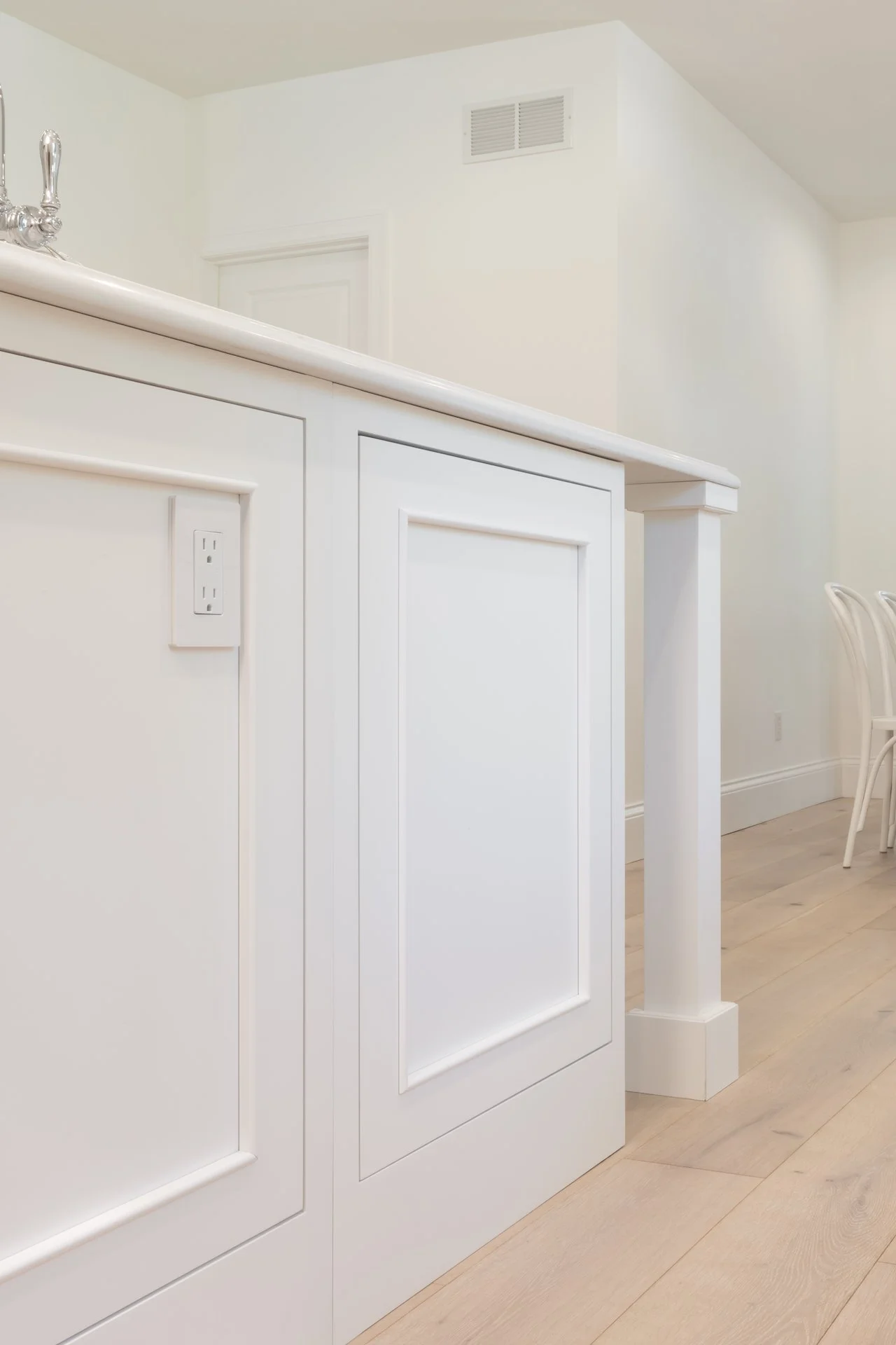 Transitional white inset kitchen with blue bar, professional appliances and brass fixtures. 