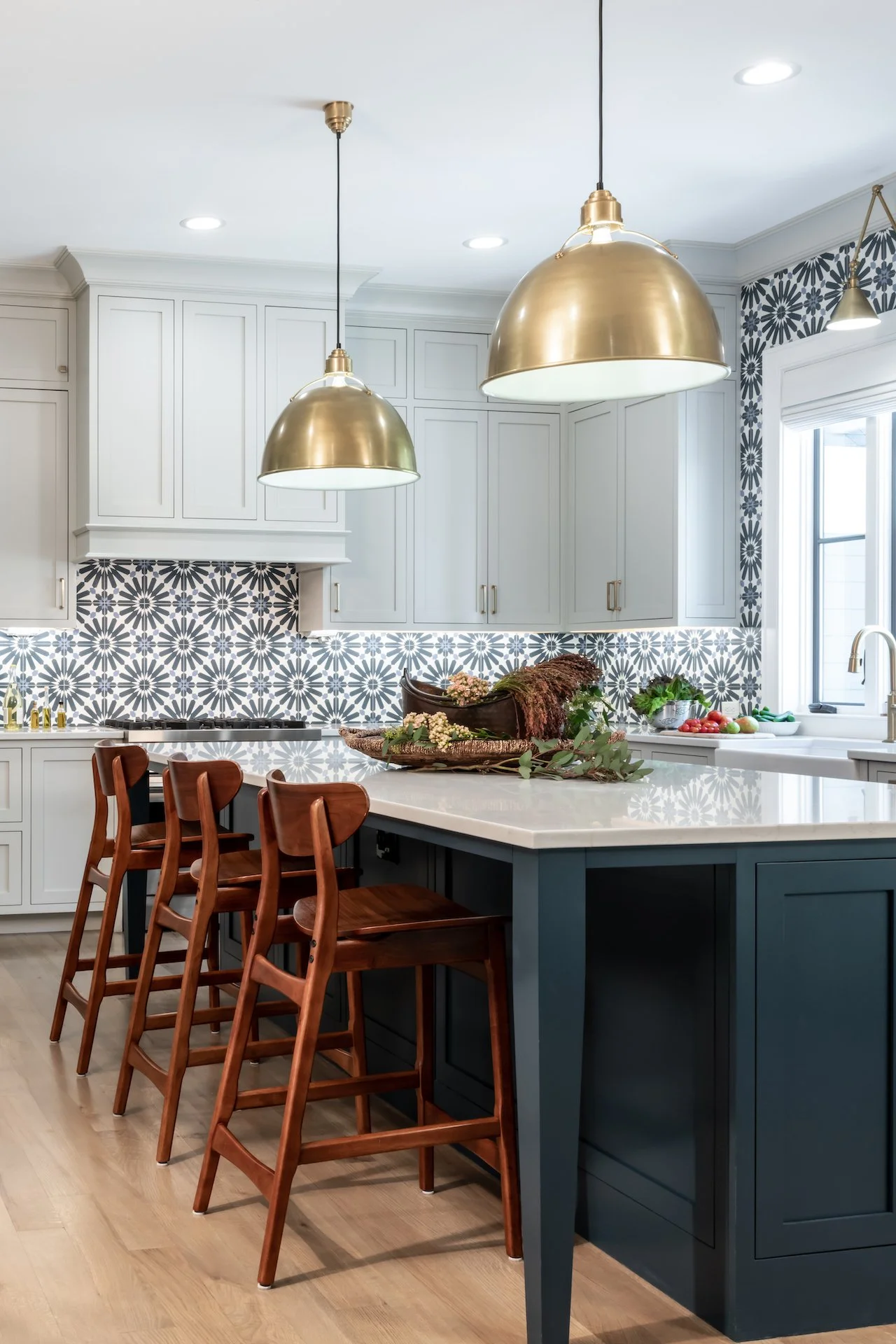 Transitional kitchen with white inset cabinets, blue island, gold fixtures and professional appliances. 