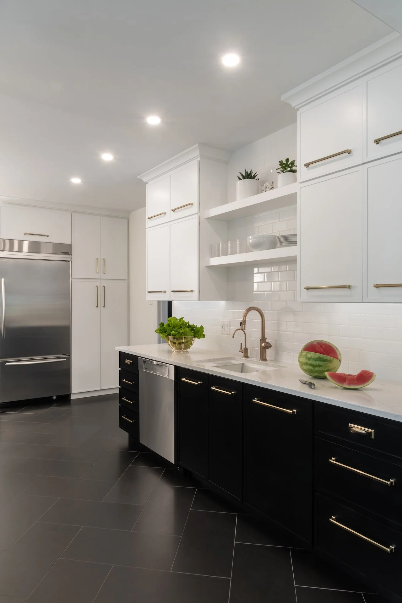 Modern kitchen in a traditional home. Black and white cabinetry and gold fixtures make this kitchen classic while updated and modern. 
