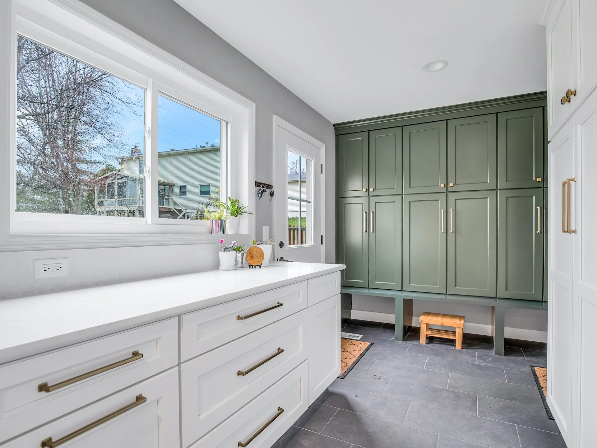 Transitional white kitchen with quartz countertops and tile splash. Adjacent Mudroom. 