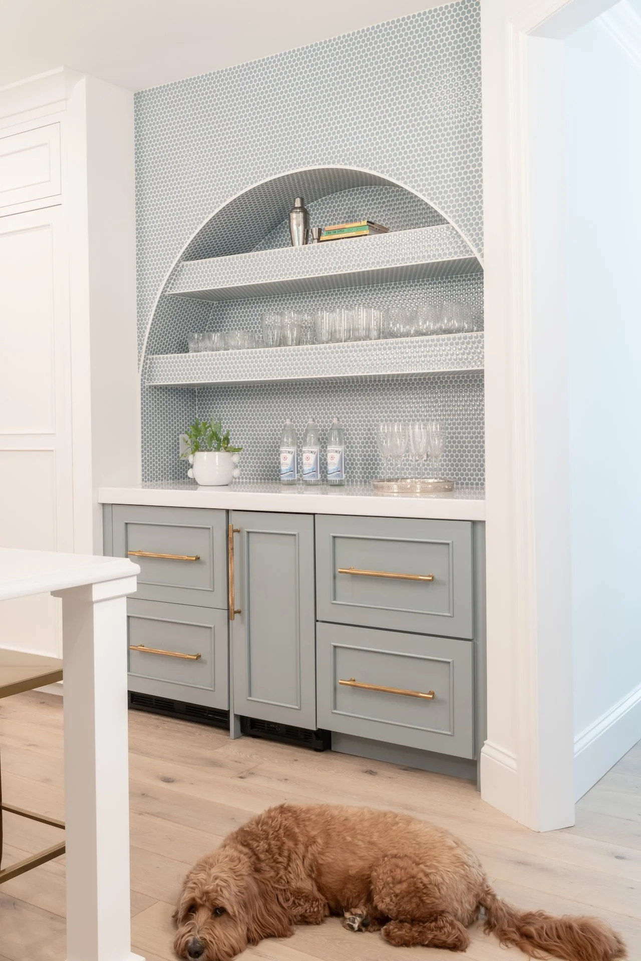 Transitional white inset kitchen with blue bar, professional appliances and brass fixtures. 