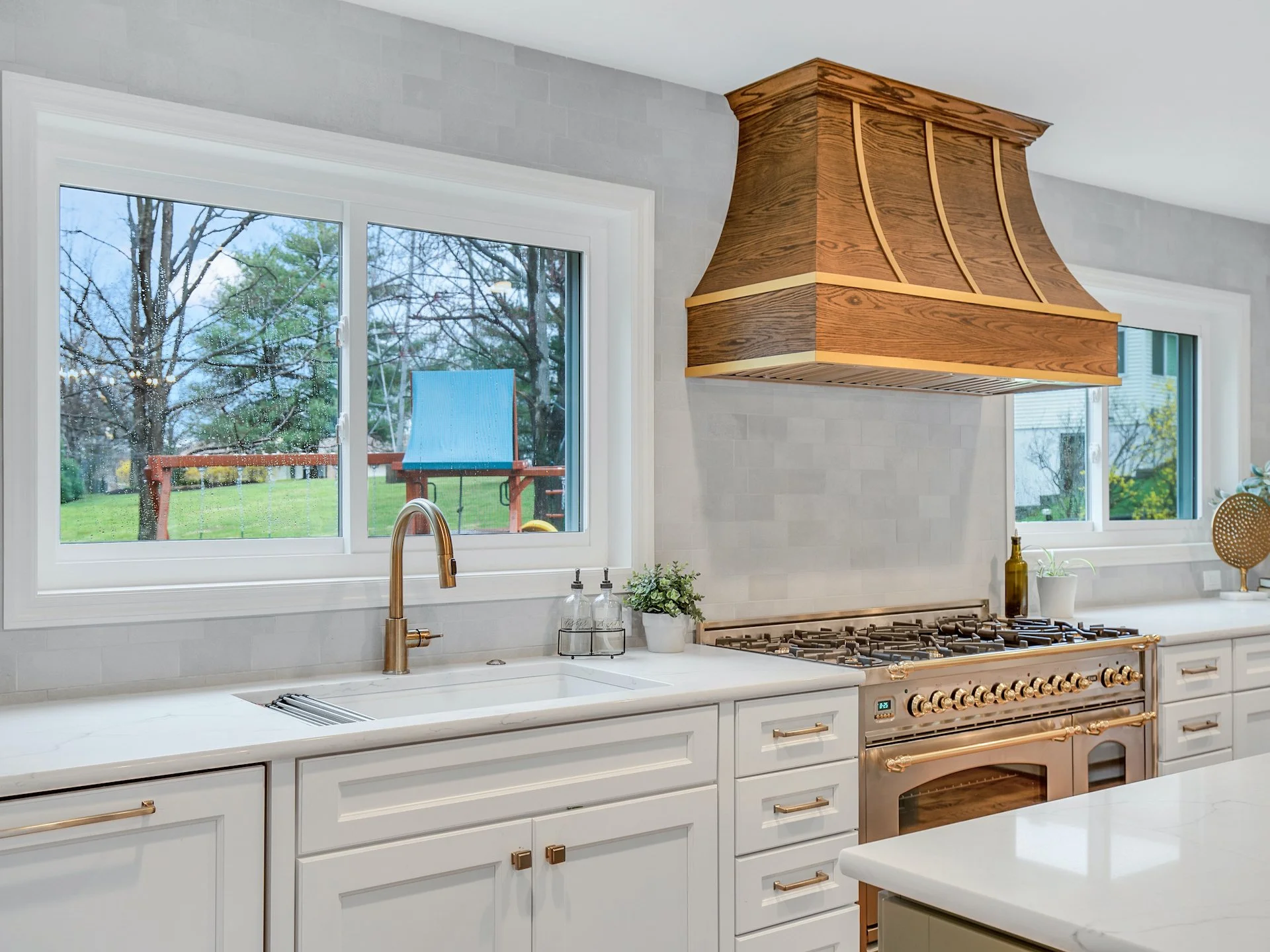 Transitional white kitchen with quartz countertops and tile splash. 