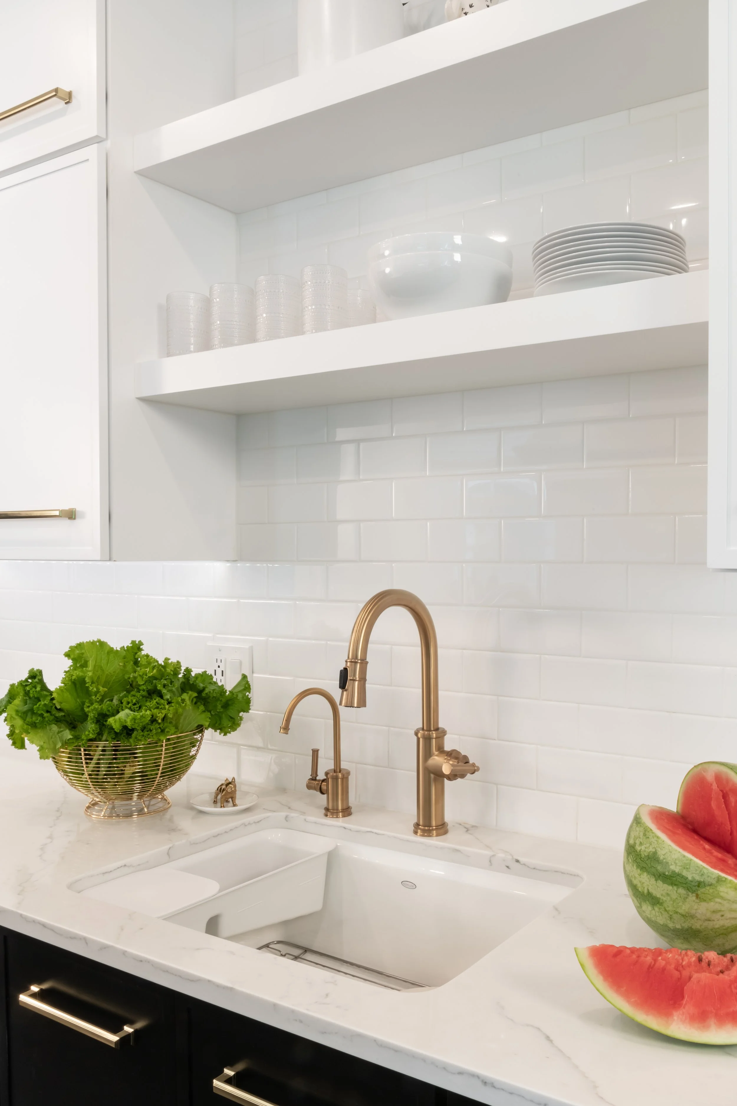 Modern kitchen in a traditional home. Black and white cabinetry and gold fixtures make this kitchen classic while updated and modern. 