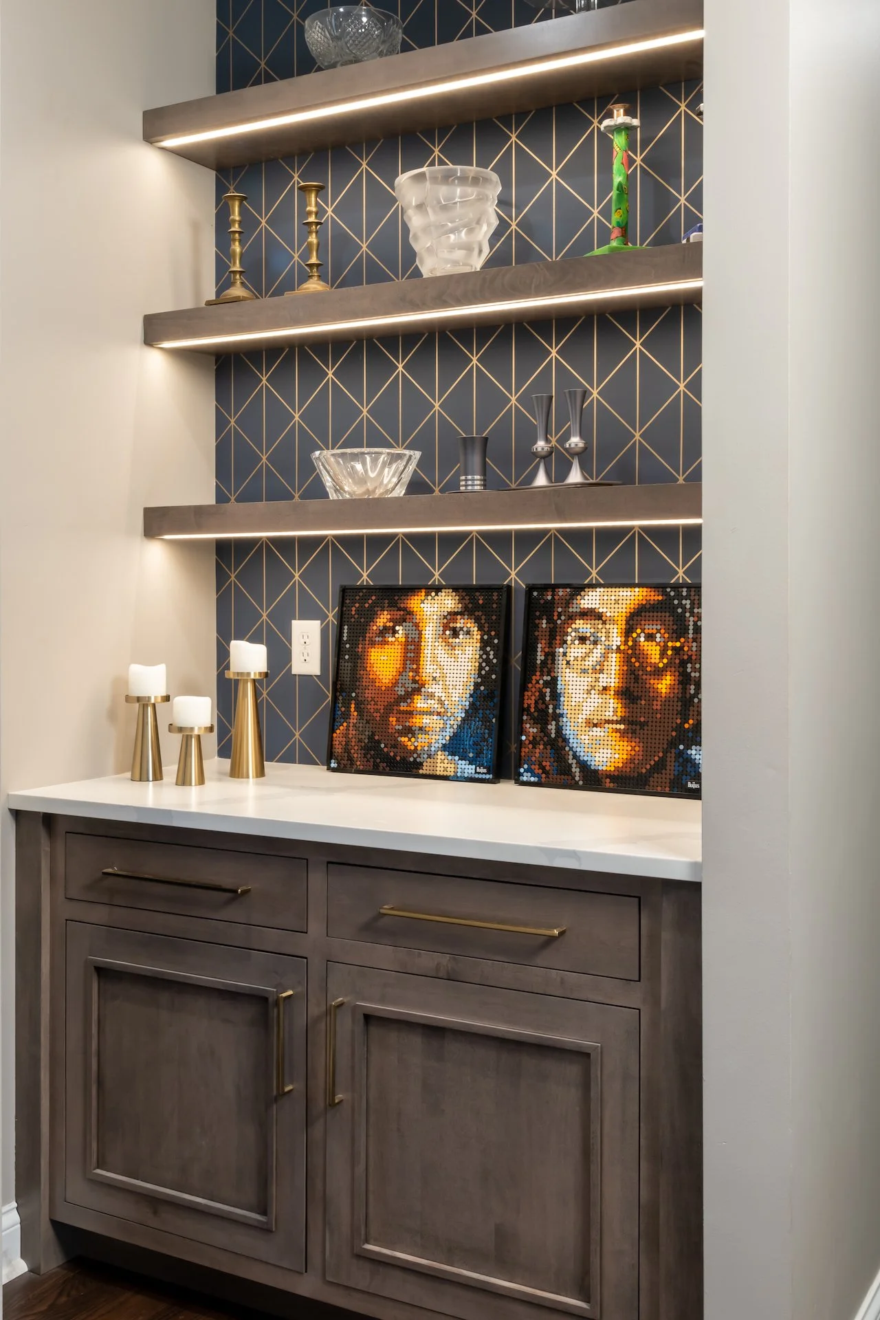 Transitional warm grey kitchen with quartz countertops, textured backsplash, professional appliances and gold fixtures.