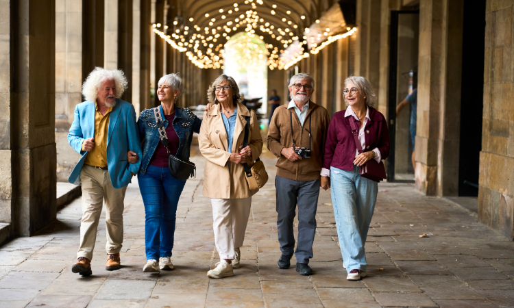 Mature Friends Walking Together Through Historic Covered Arcade.png