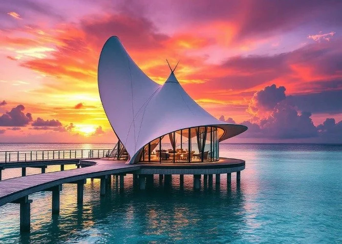 Modern Maldives building on stilts over ocean at sunset.jpeg