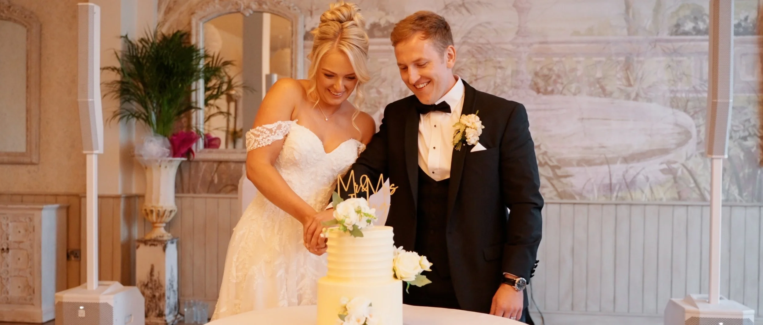 A bride & groom cutting wedding cake from a wedding film at Wennington Hall, Lancaster