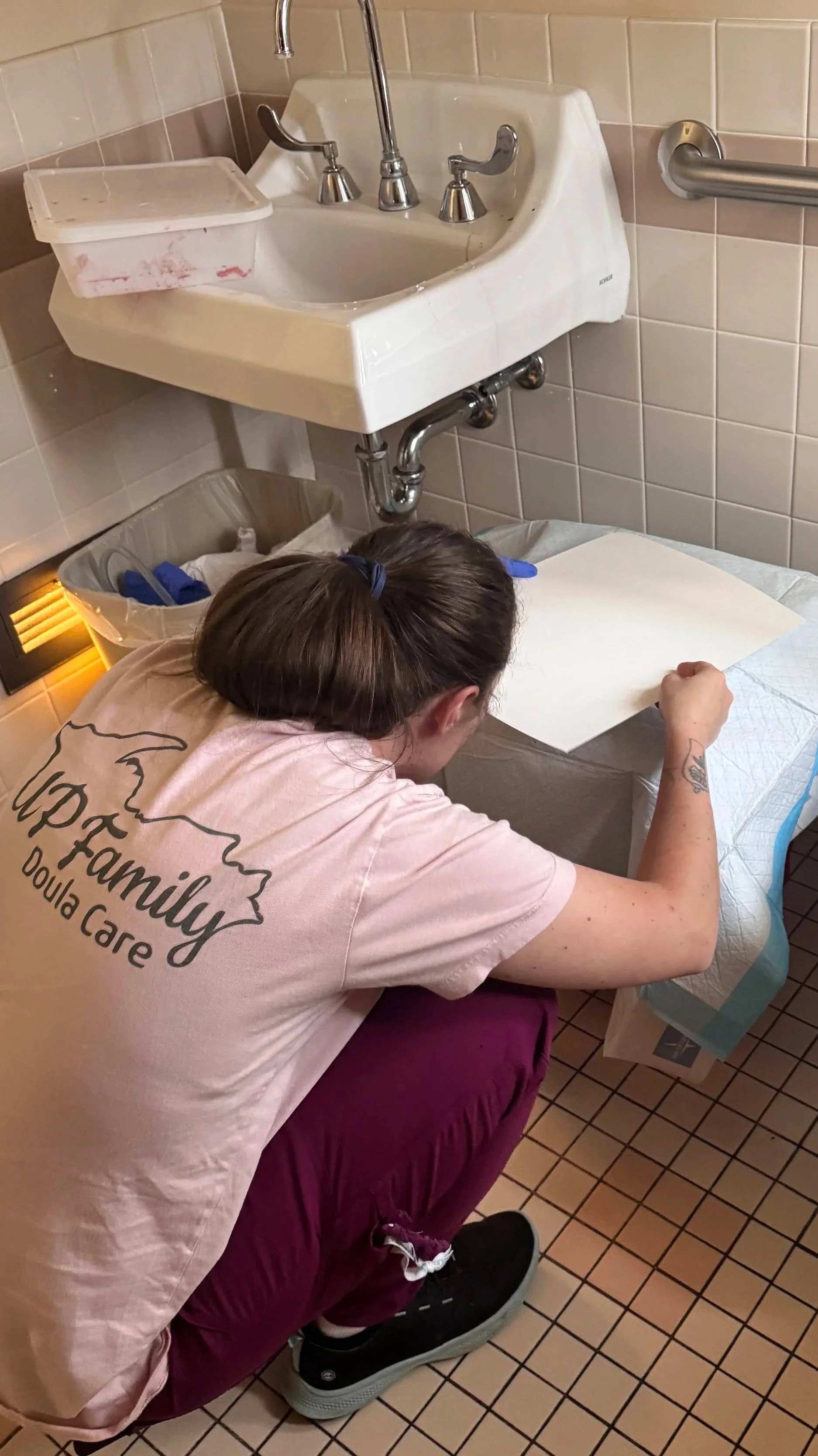 doula lacy is painting a placenta in a hospital bathroom