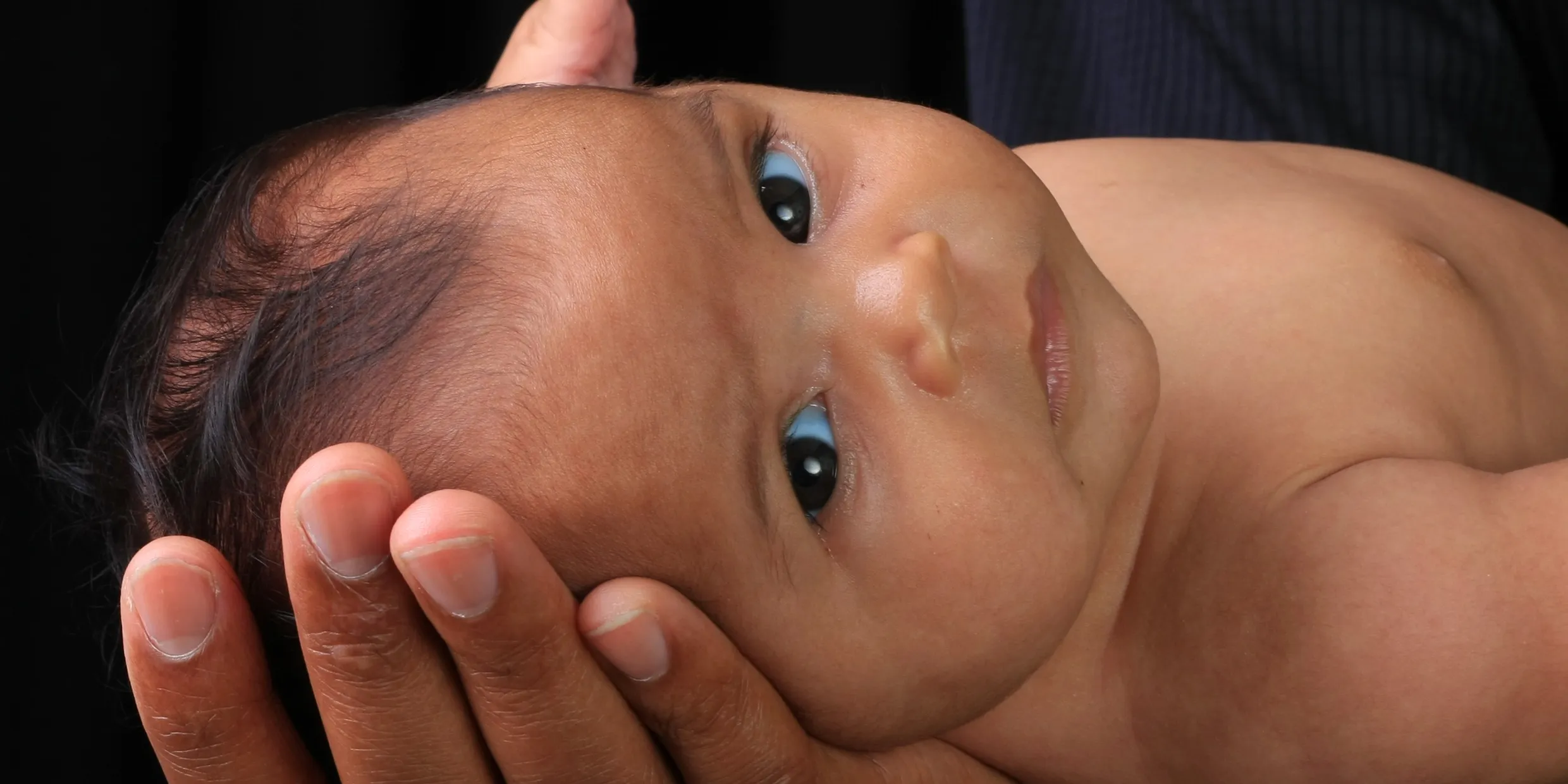 A newborn baby supported by kangaroula doula in Marquette, Michigan.