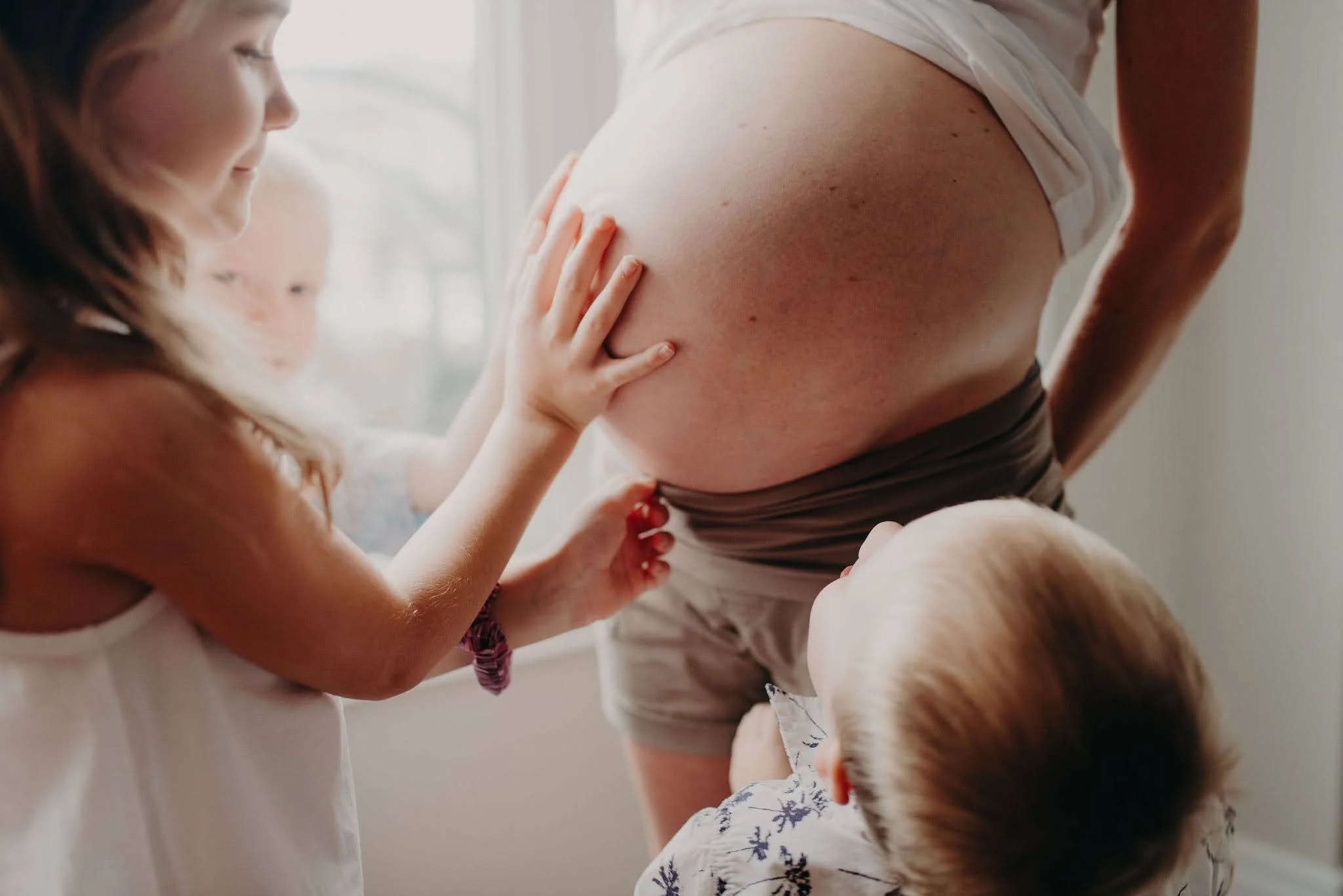 A Marquette County family poses in home while supported by a compassionate birth doula.