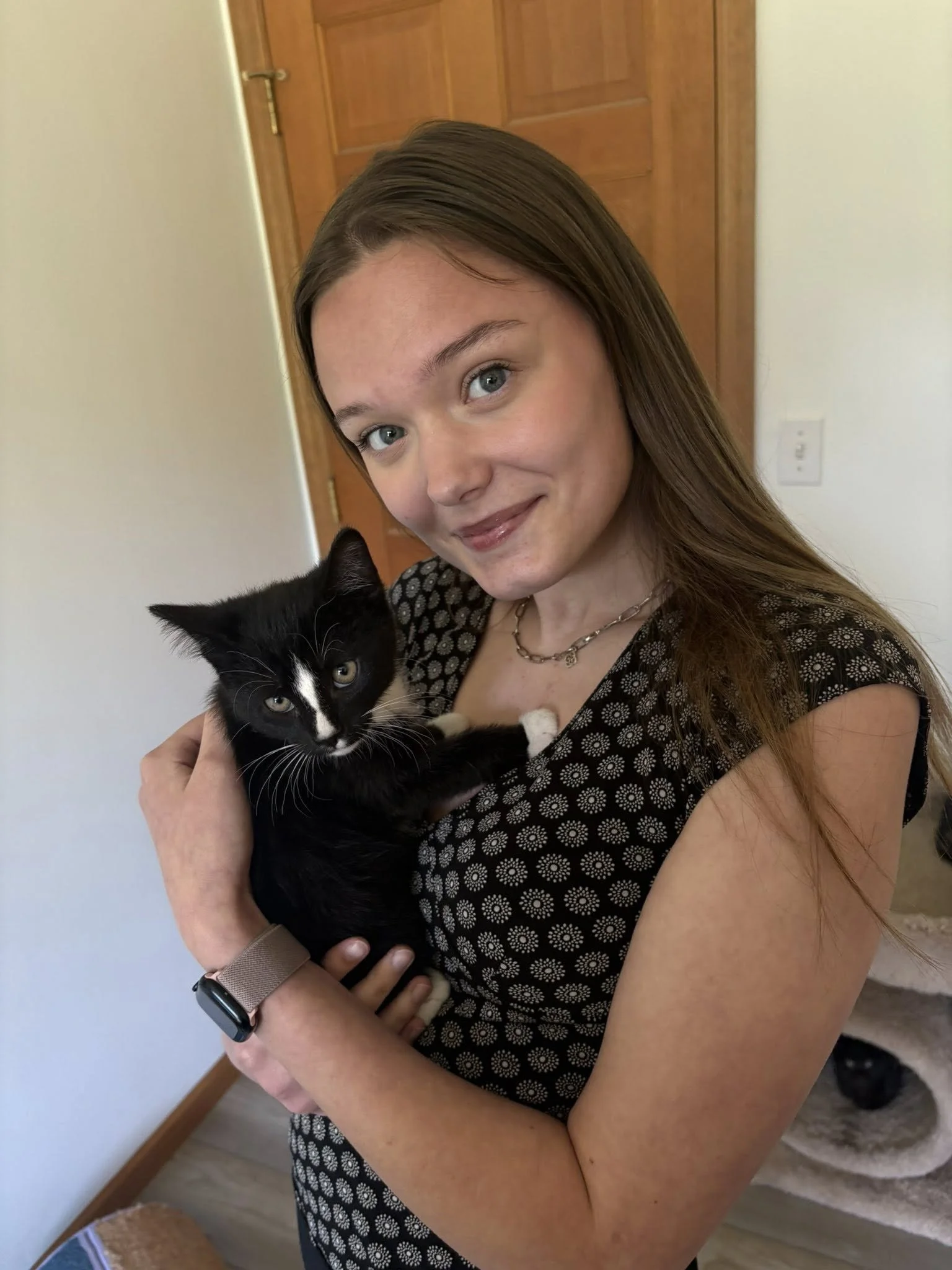 UP Family Doula Care team member, Grace Anderson, posing with black cat in Marquette home.