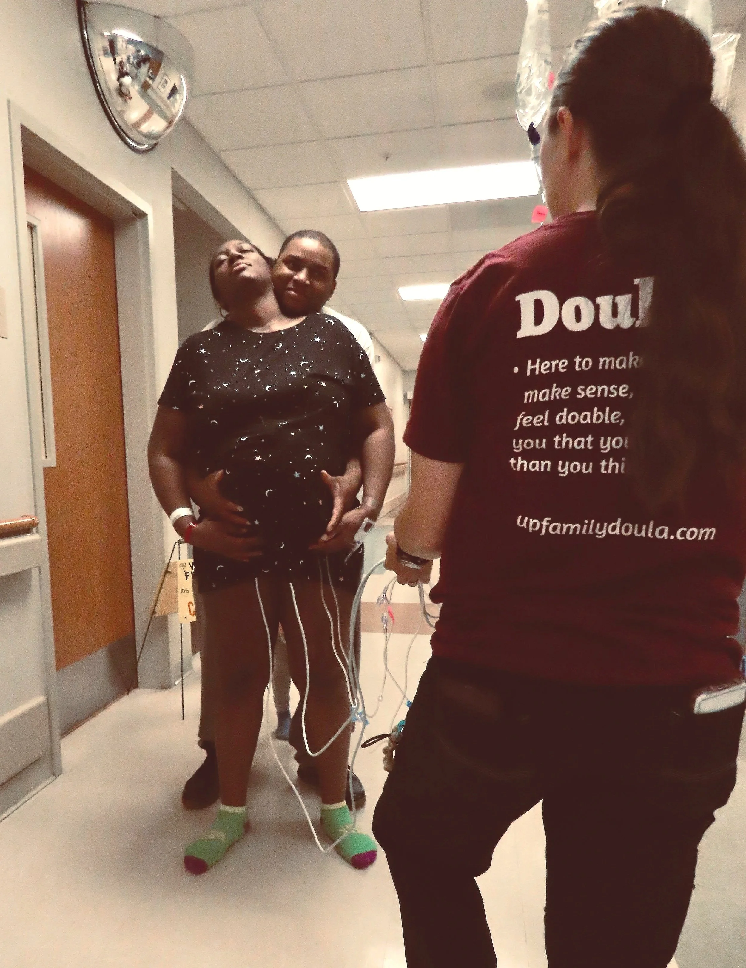 Mother in labor within the hospital, with support of her husband and doula lacy anderson