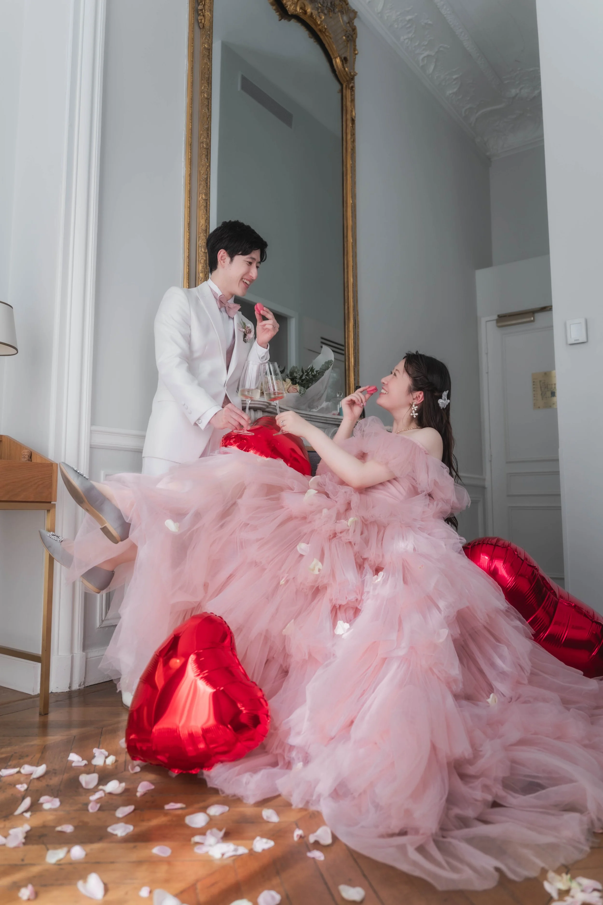 結婚式の新郎と新婦が室内で幸せそうに笑いながらお互いにキャンディを交換しているシーン。