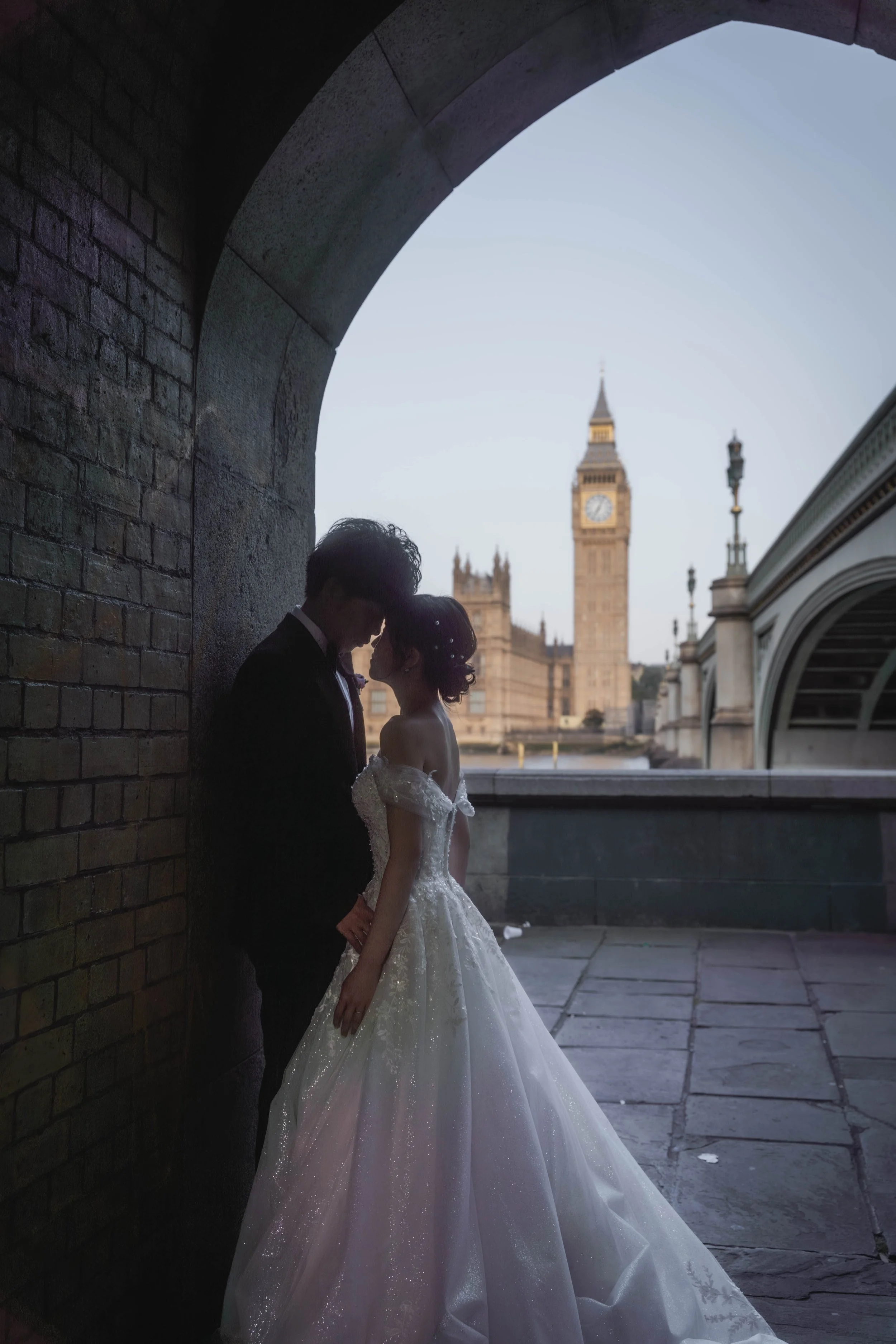 ビクトリアアーチの下で、ロンドンのビッグベンとウェストミンスター宮殿を背景にしているカップルのウェディング写真.